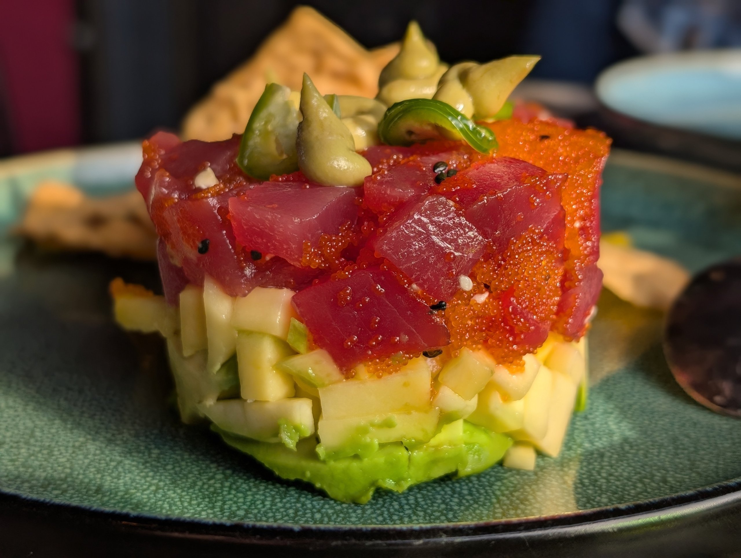 Truffle tuna tartare at Ostras Lounge, layered with avocado, mango cubes, tuna, tobiko, and avocado mousse