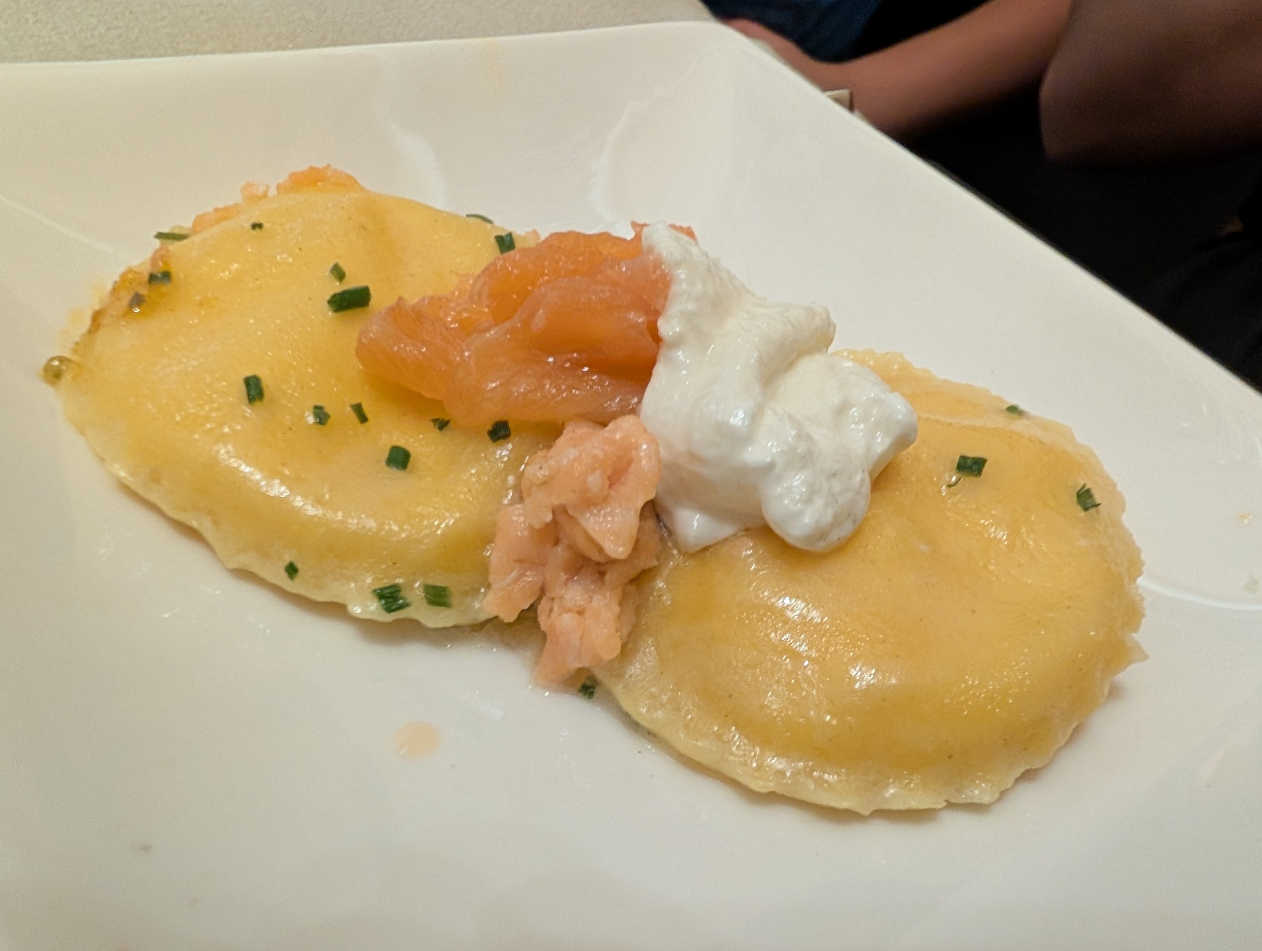 Two large round ravioli with smoked salmon, chives, and a quenelle of cream at Ristorante Ad Hoc, Rome