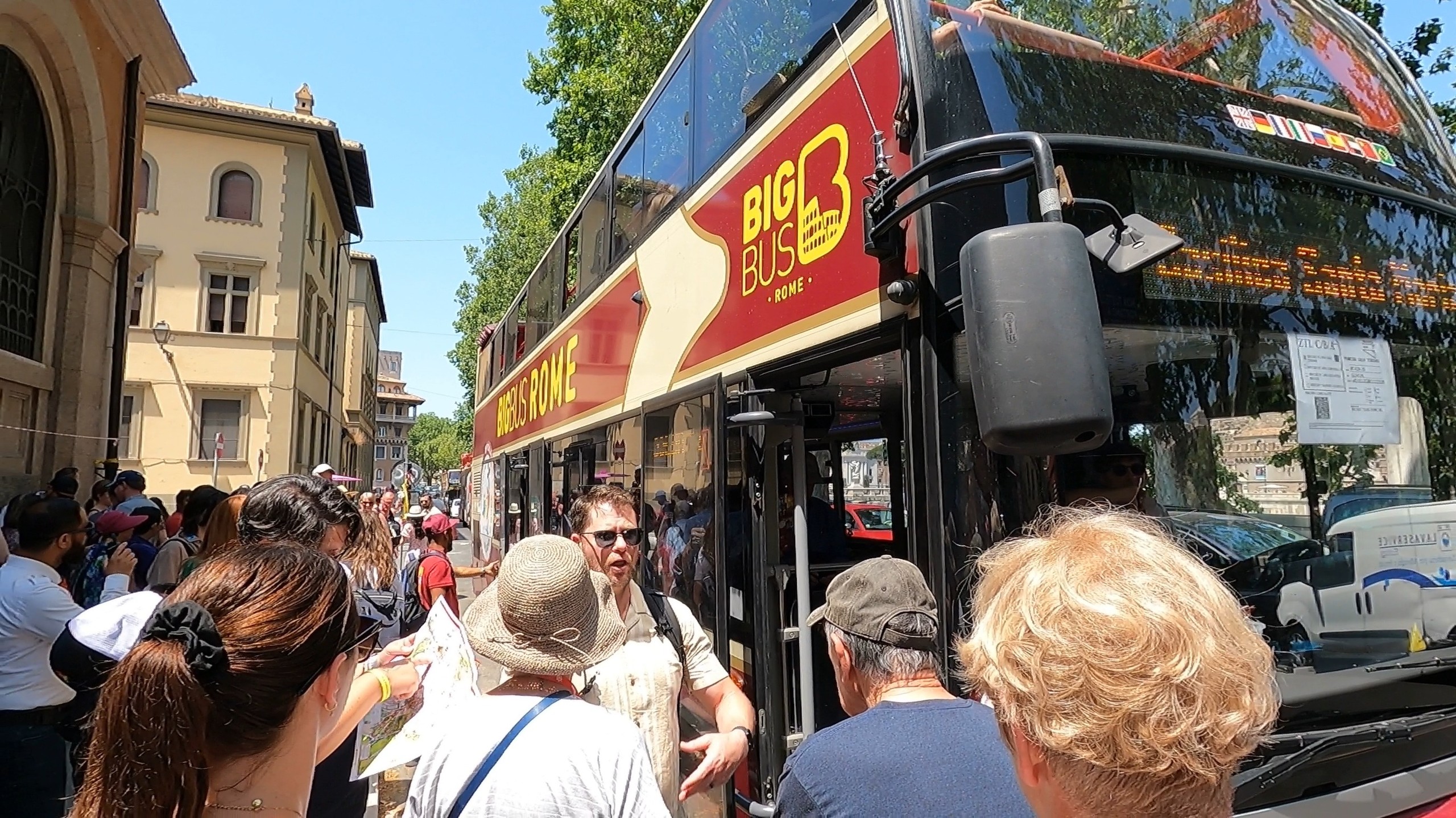 Big Bus Rome Hop-On / Hop-Off double-decker at a curbside stop with passengers on the sidewalk