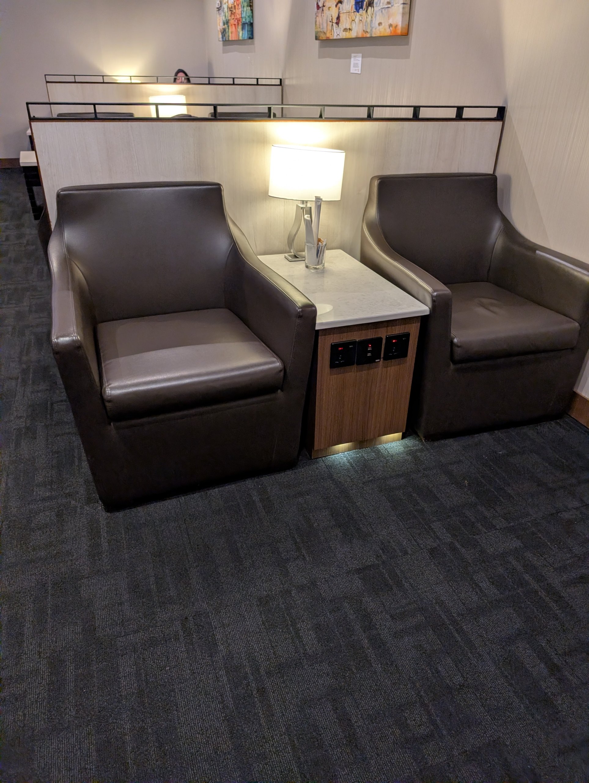 Quiet art alcove with two leather club chairs and a marble side table at the SATS Premier Lounge Changi T2