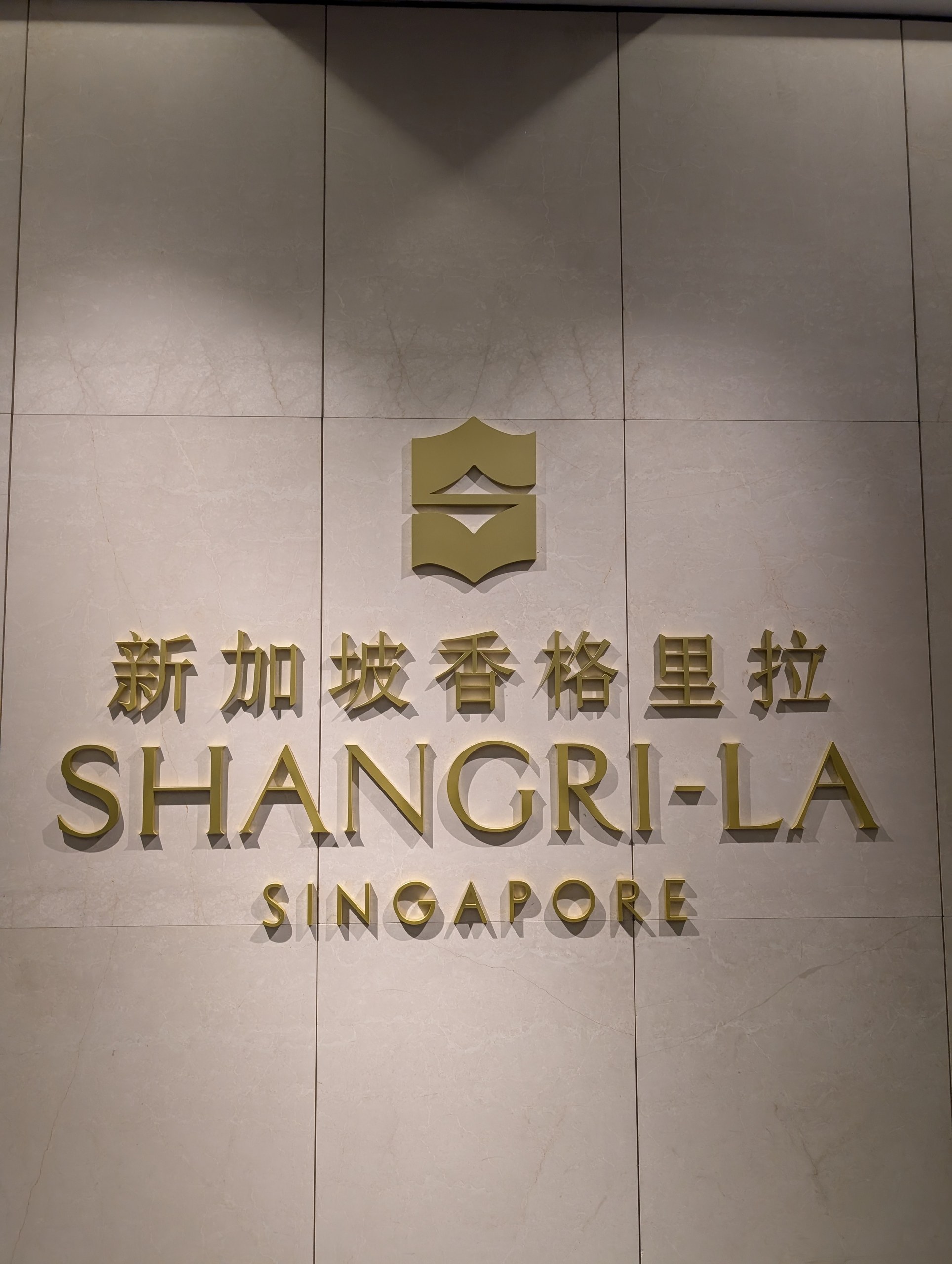 The Shangri-La Singapore wordmark in gold on the lobby wall.