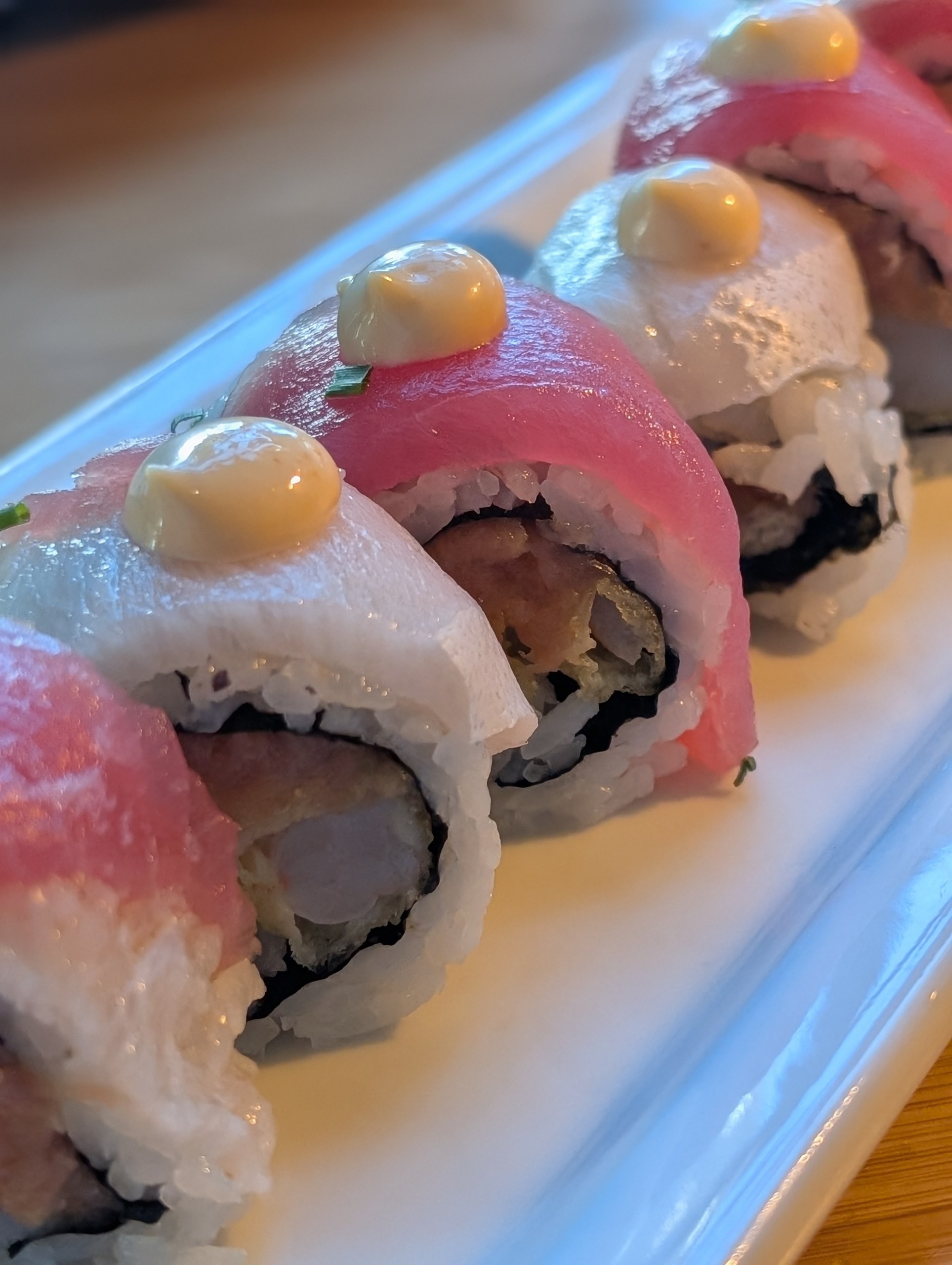 Katana signature roll at Sushi Roku Las Vegas topped with alternating tuna and yellowtail and dotted with spicy mayo, with spicy tuna and shrimp tempura inside