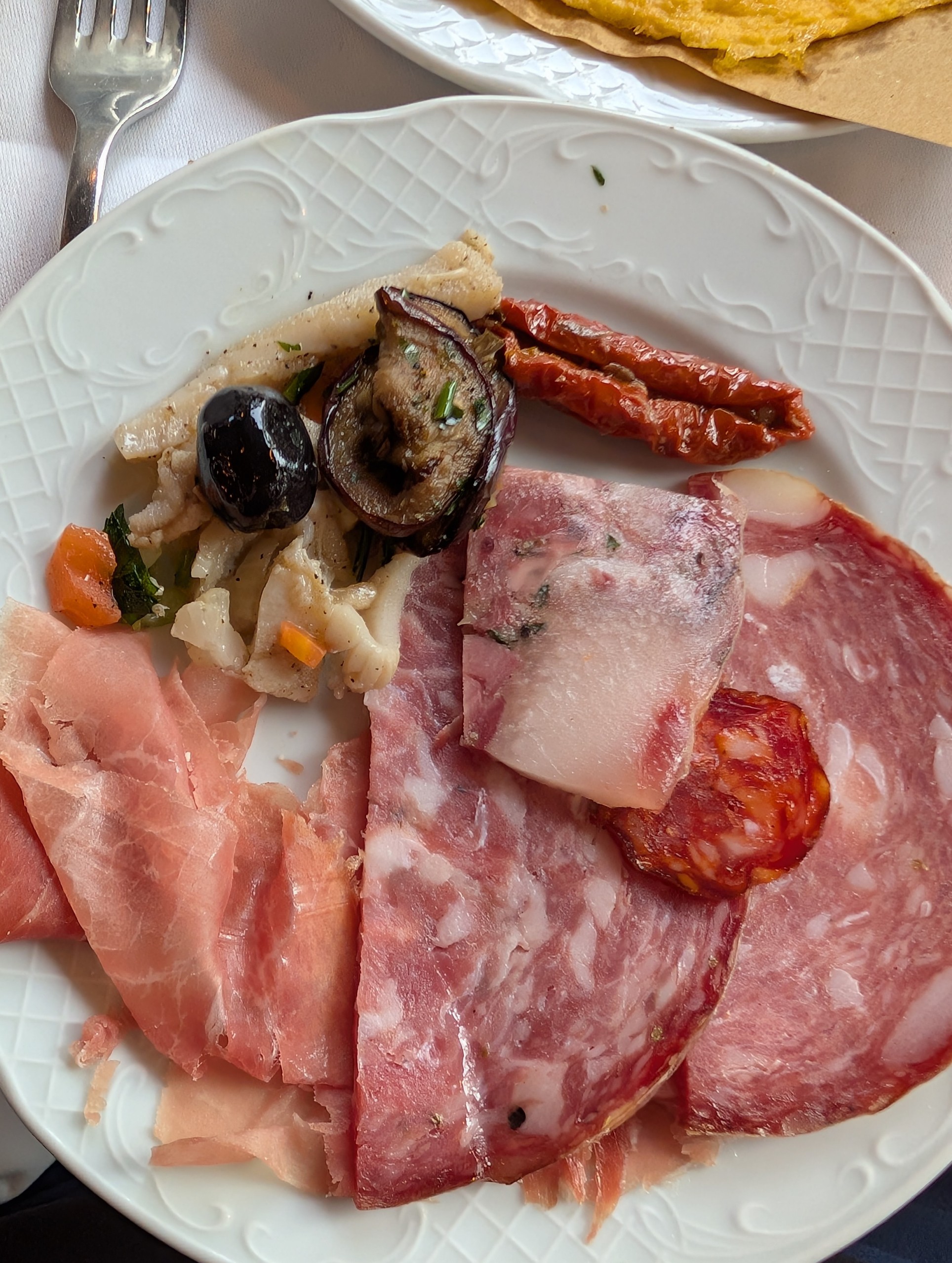 Tuscan antipasto board at Trattoria Zà-Zà, Florence: prosciutto, salame, capocollo, lardo, mortadella, grilled eggplant, sun-dried tomatoes, olives