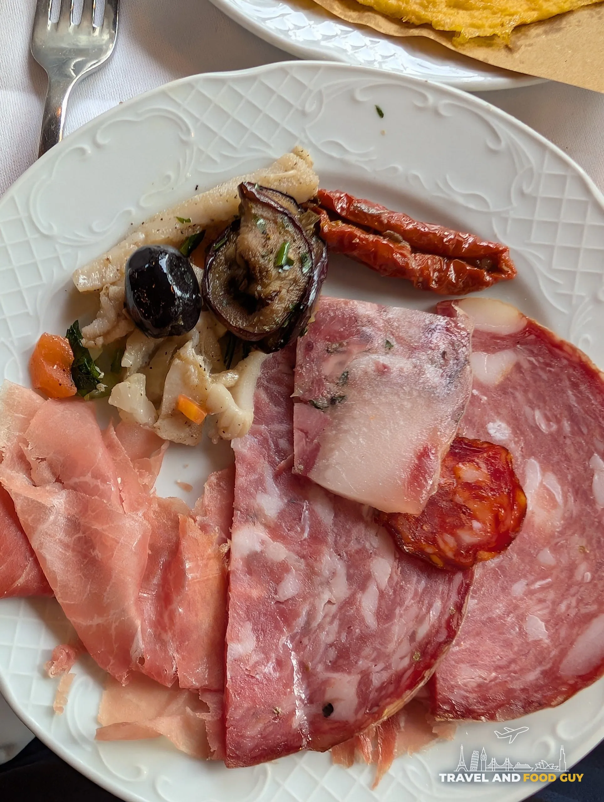 Tuscan antipasto board at Trattoria Zà-Zà, Florence: prosciutto, salame, capocollo, lardo, mortadella, grilled eggplant, sun-dried tomatoes, olives