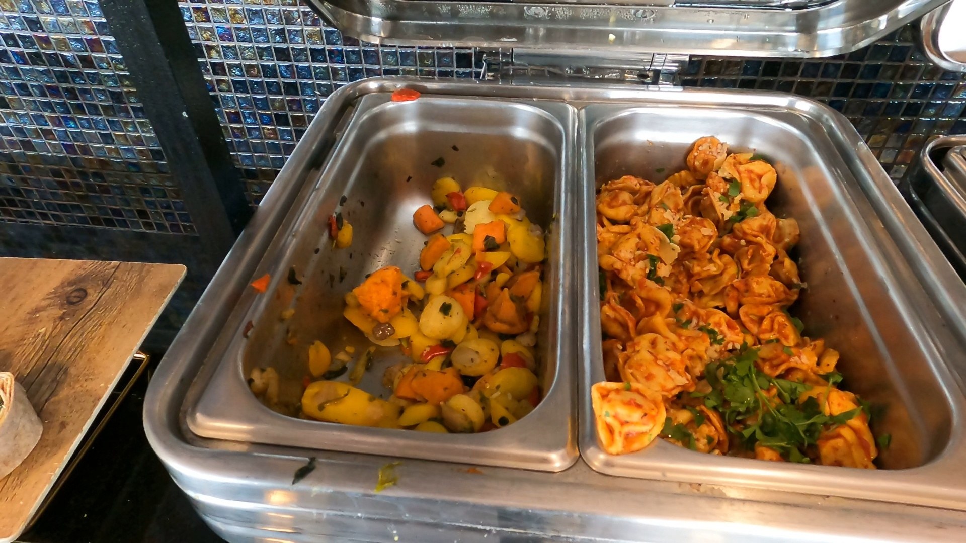 Hot food buffet at the United Club LAS with tortellini in red sauce and stewed potato and vegetable chafer