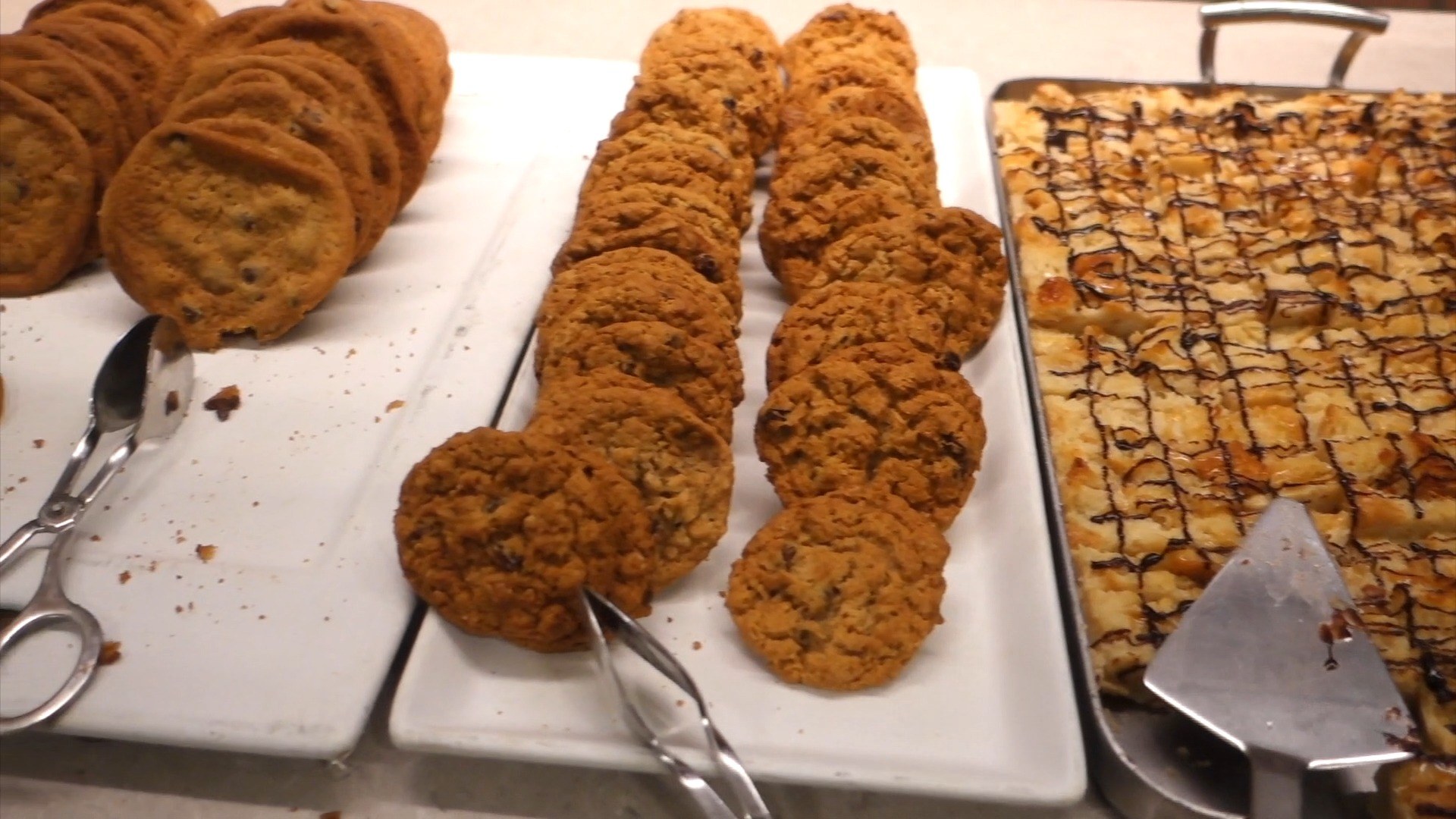 Trays of chocolate chip and oatmeal cookies plus chocolate-drizzled almond bars on the dessert counter at the United Club at ORD Concourse C.