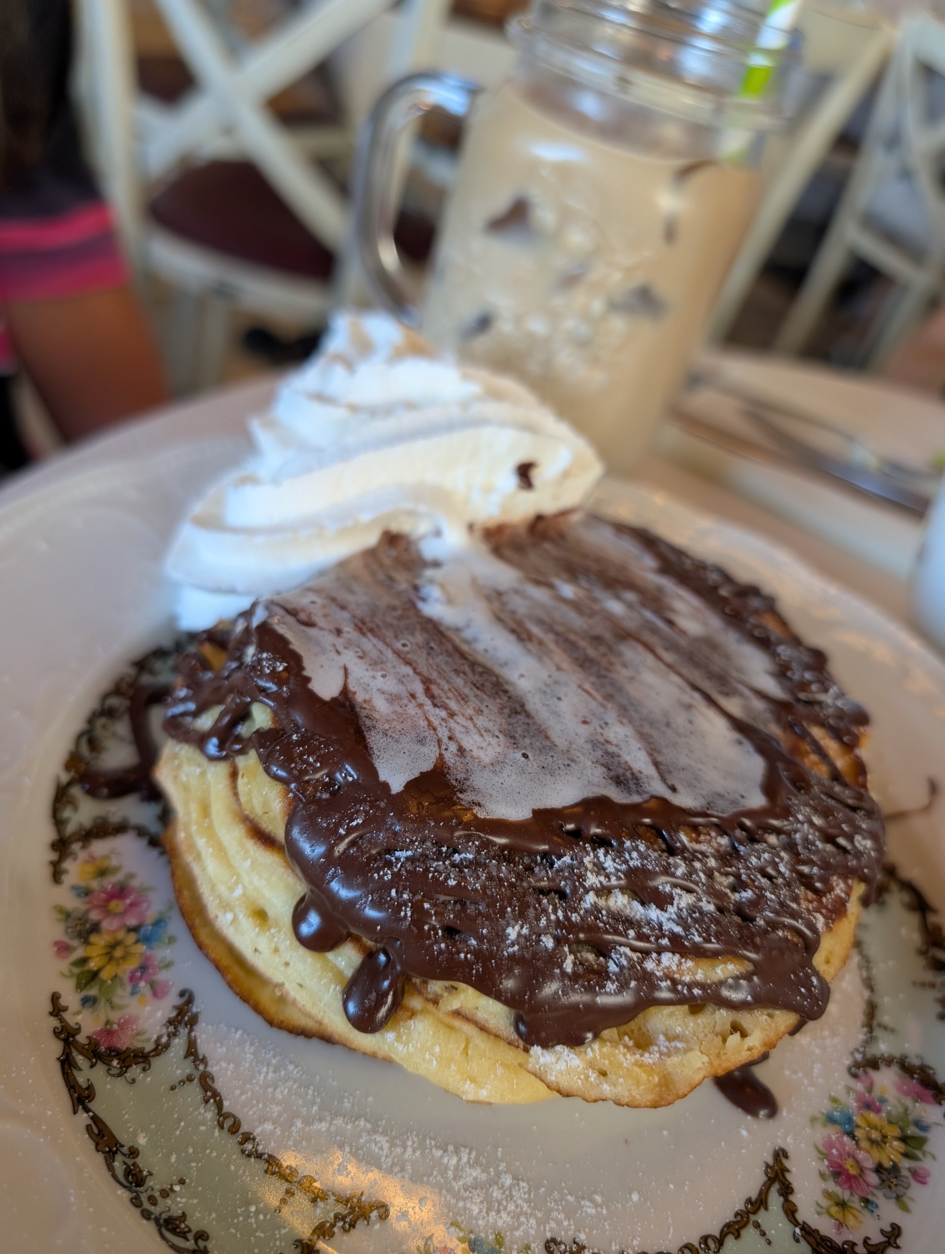 Pancake stack with chocolate sauce and iced coffee in mason jar at VaLù Bakery, Florence