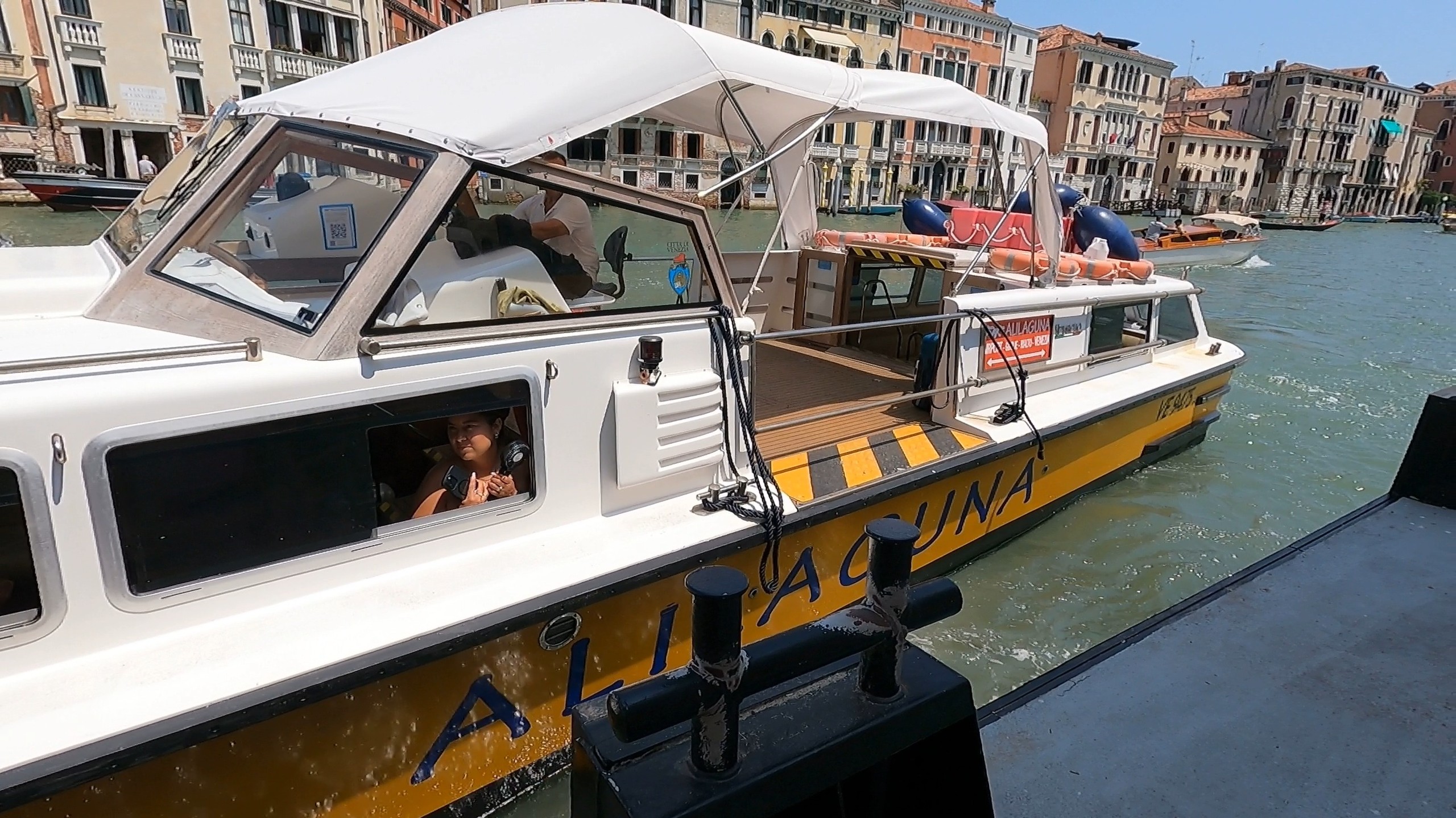 An Alilaguna water boat docked along the Venice Grand Canal with palazzi in the background
