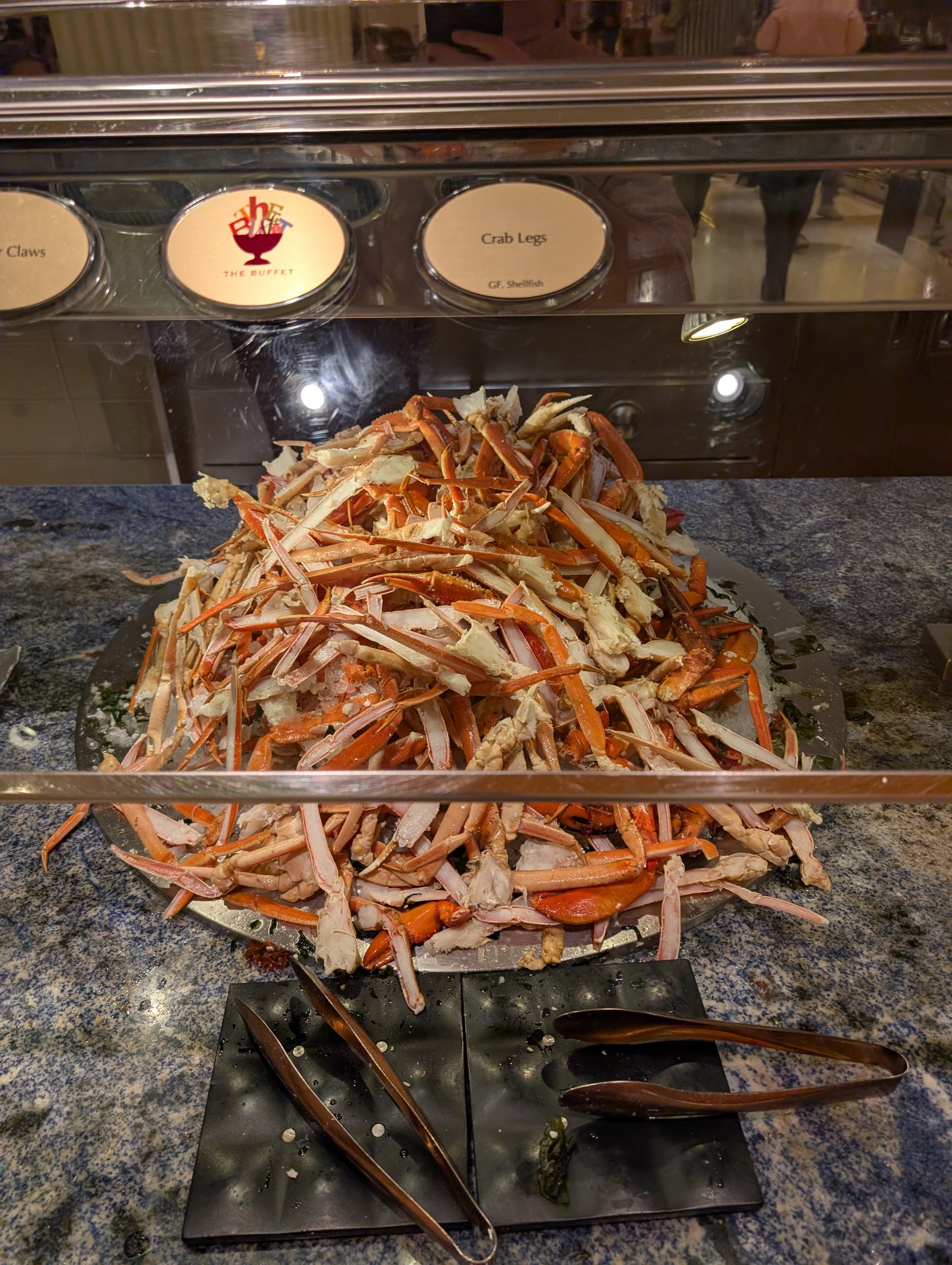 Mountain of fresh crab legs piled in a serving tray with melted butter alongside at The Buffet at Wynn