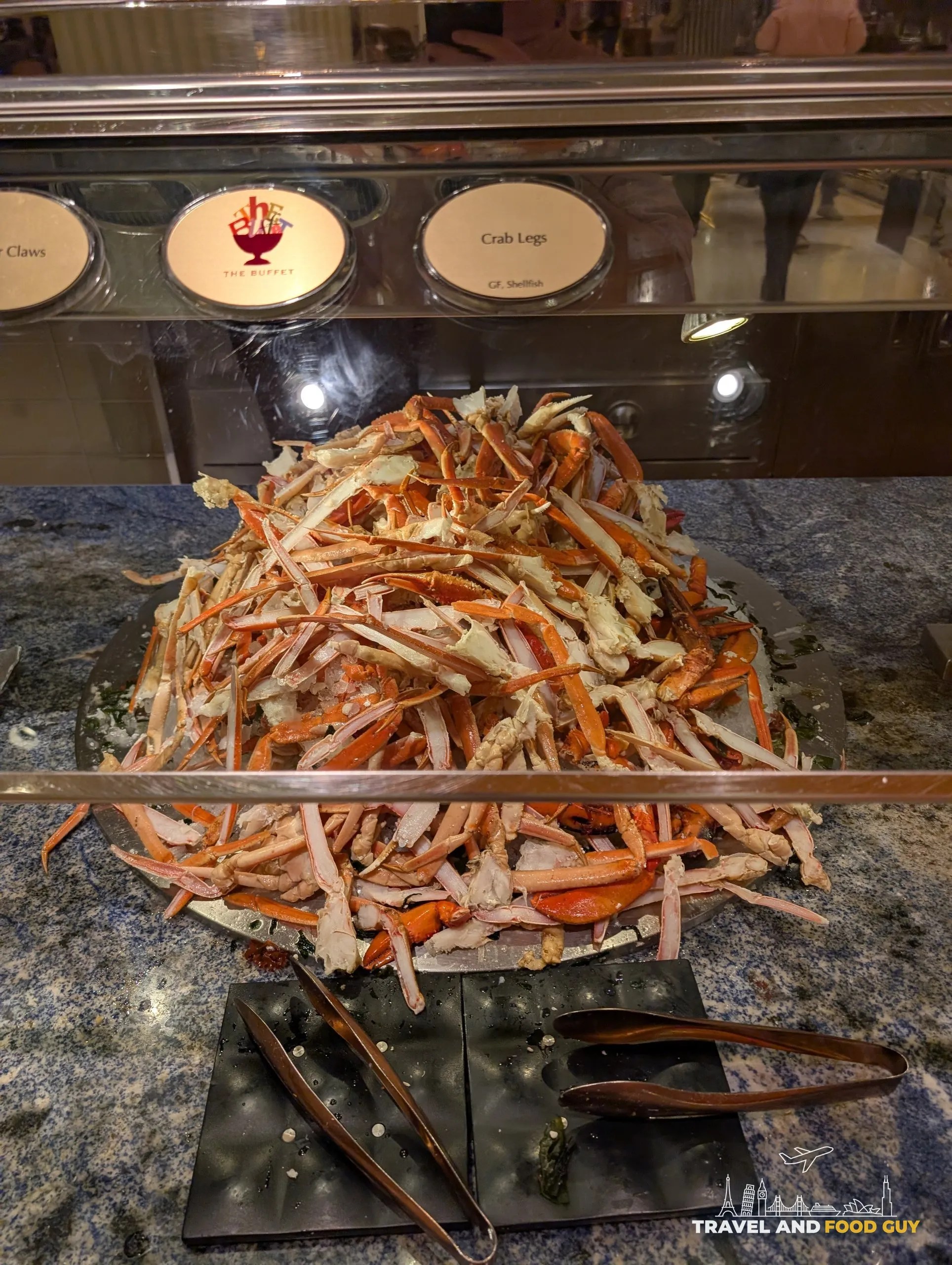 Mountain of fresh crab legs piled in a serving tray with melted butter alongside at The Buffet at Wynn