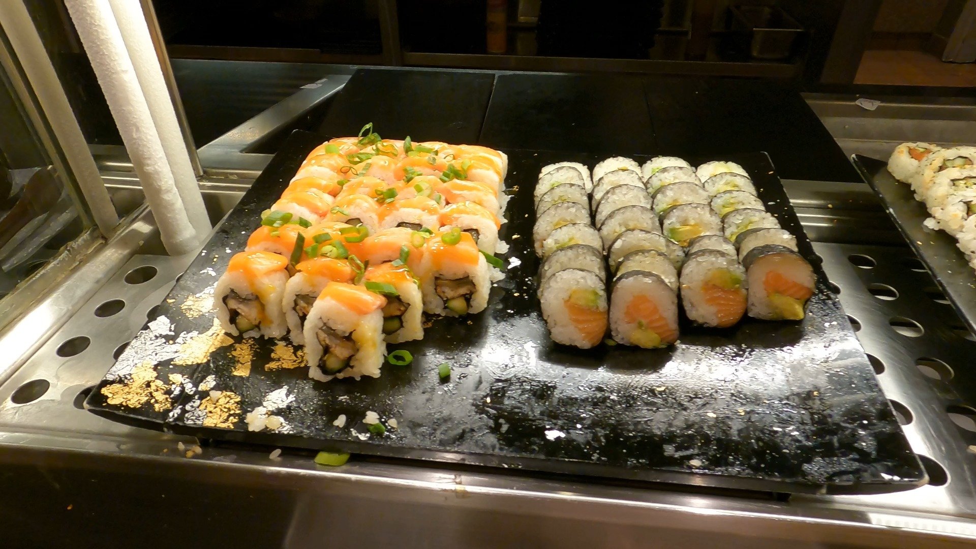 Salmon avocado roll on a black tray at The Buffet at Wynn sushi station