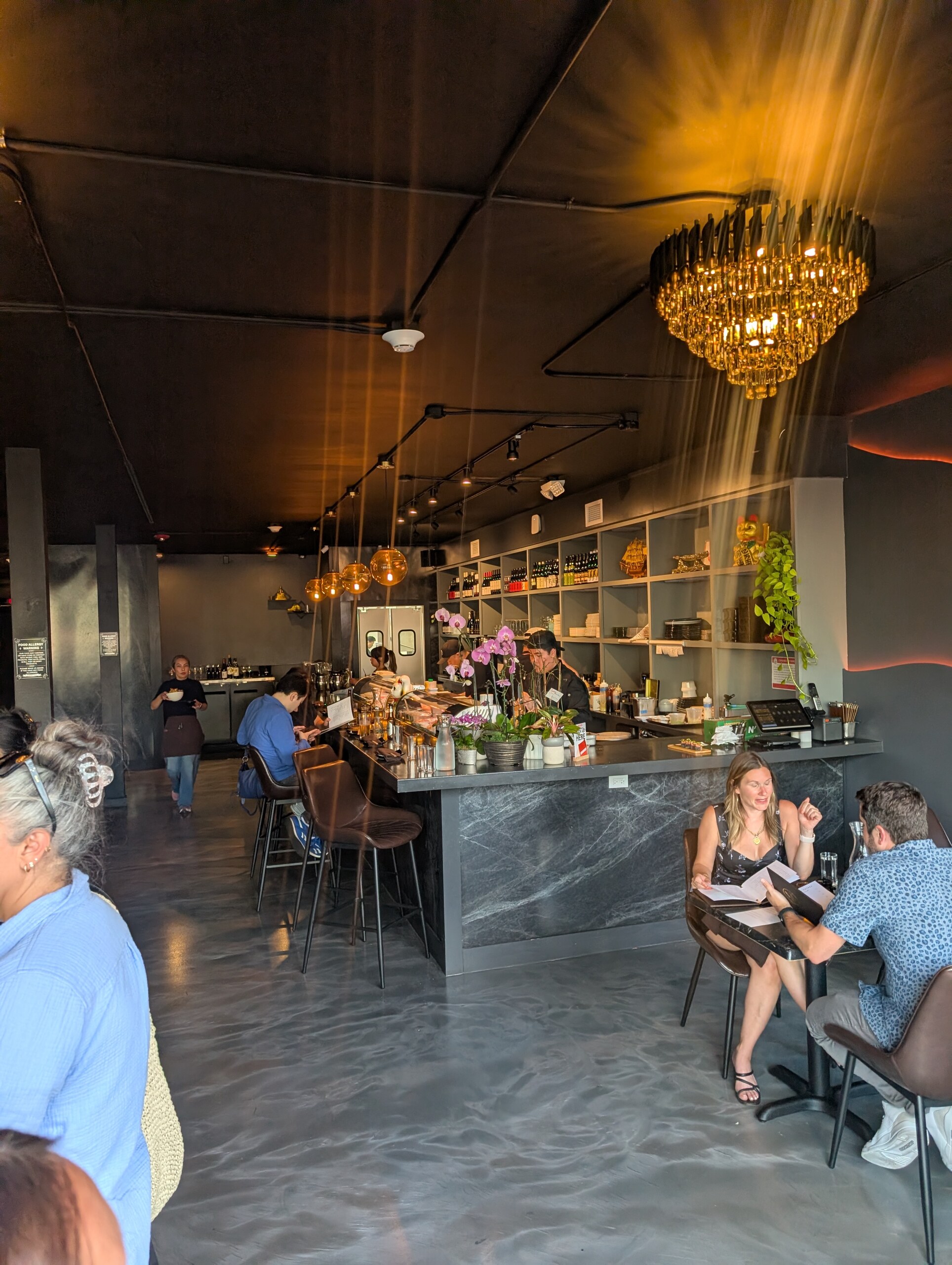 Deba Sushi Bar dining room with sushi counter and chandelier