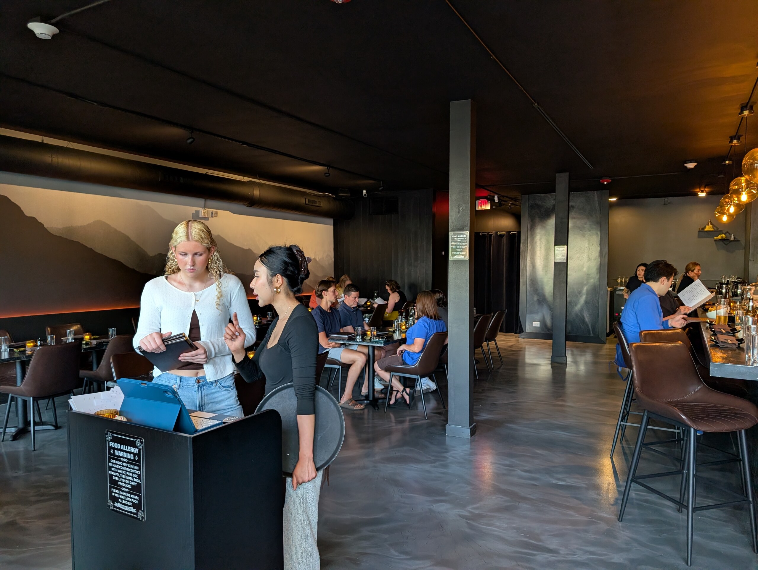 Deba Sushi Bar dining room with mountain mural and host stand