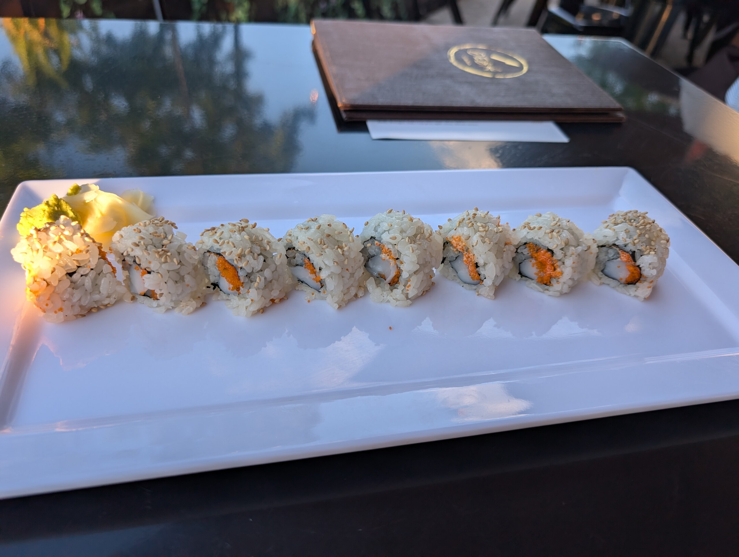 Spicy scallop roll at Deba Sushi Bar topped with sesame and masago