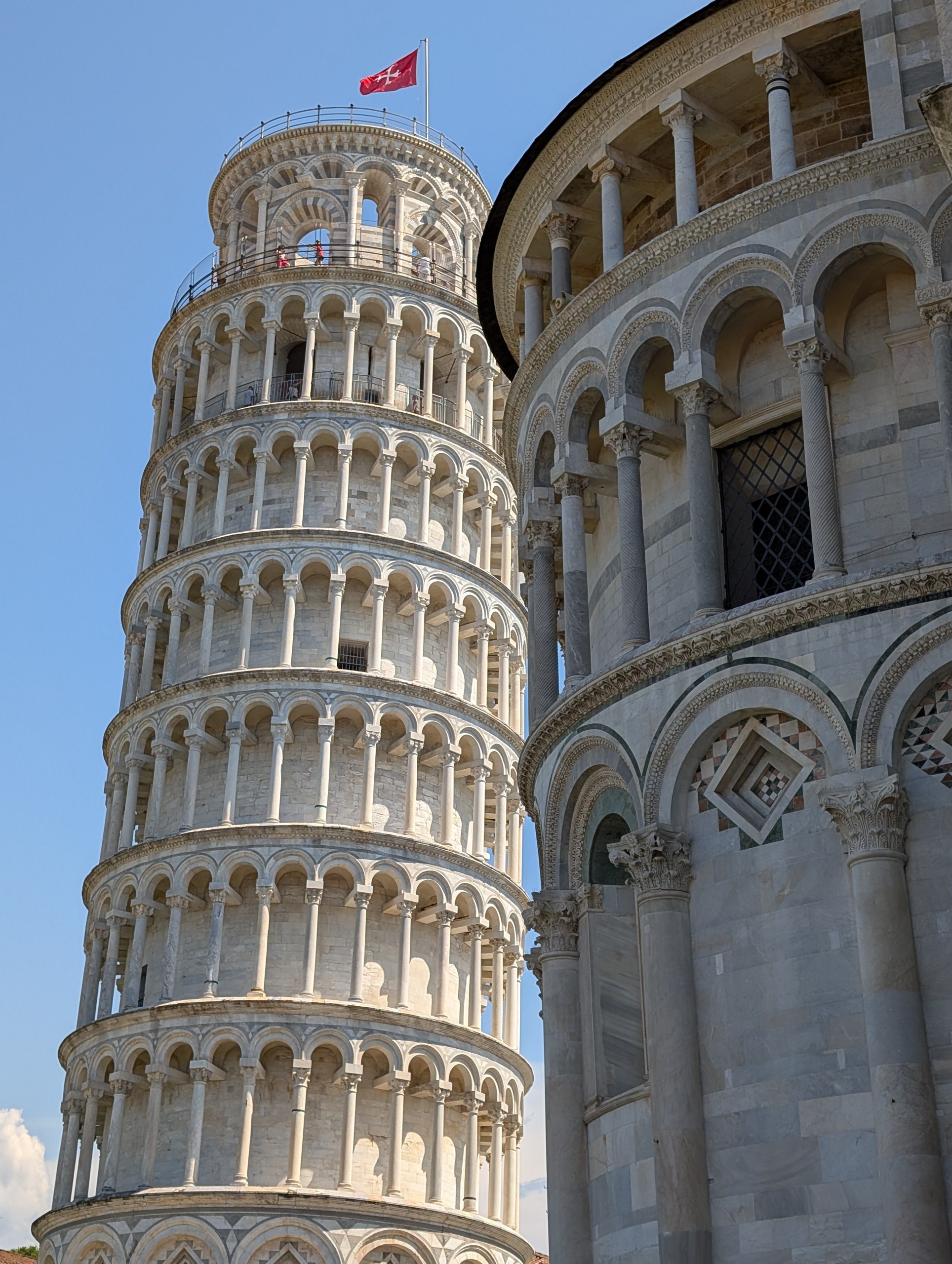The Leaning Tower of Pisa against the skyline next to the Cathedral apse
