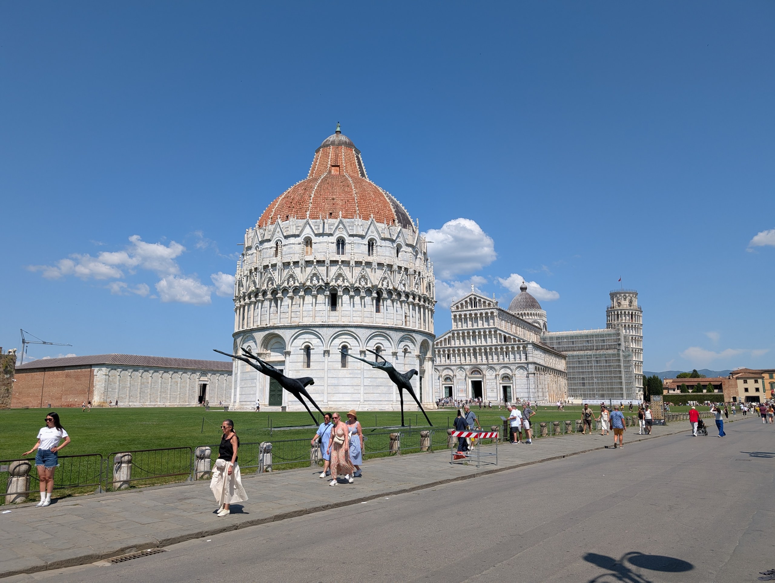 First view of the Square of Miracles in Pisa, the Leaning Tower, Baptistery and Cathedral together in white marble