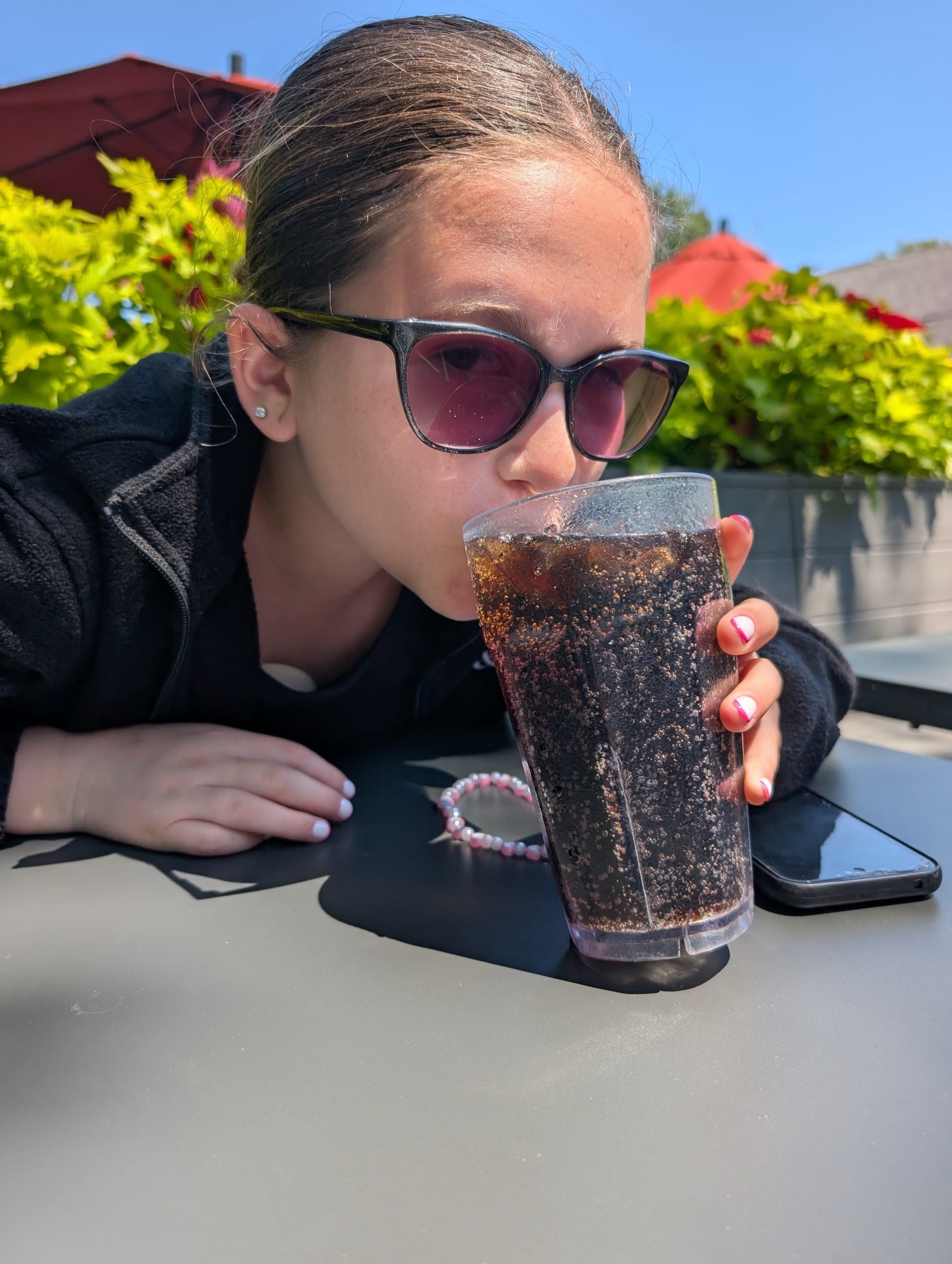 Girl drinking a Cherry Pepsi at a patio table at Lou Malnati's Buffalo Grove