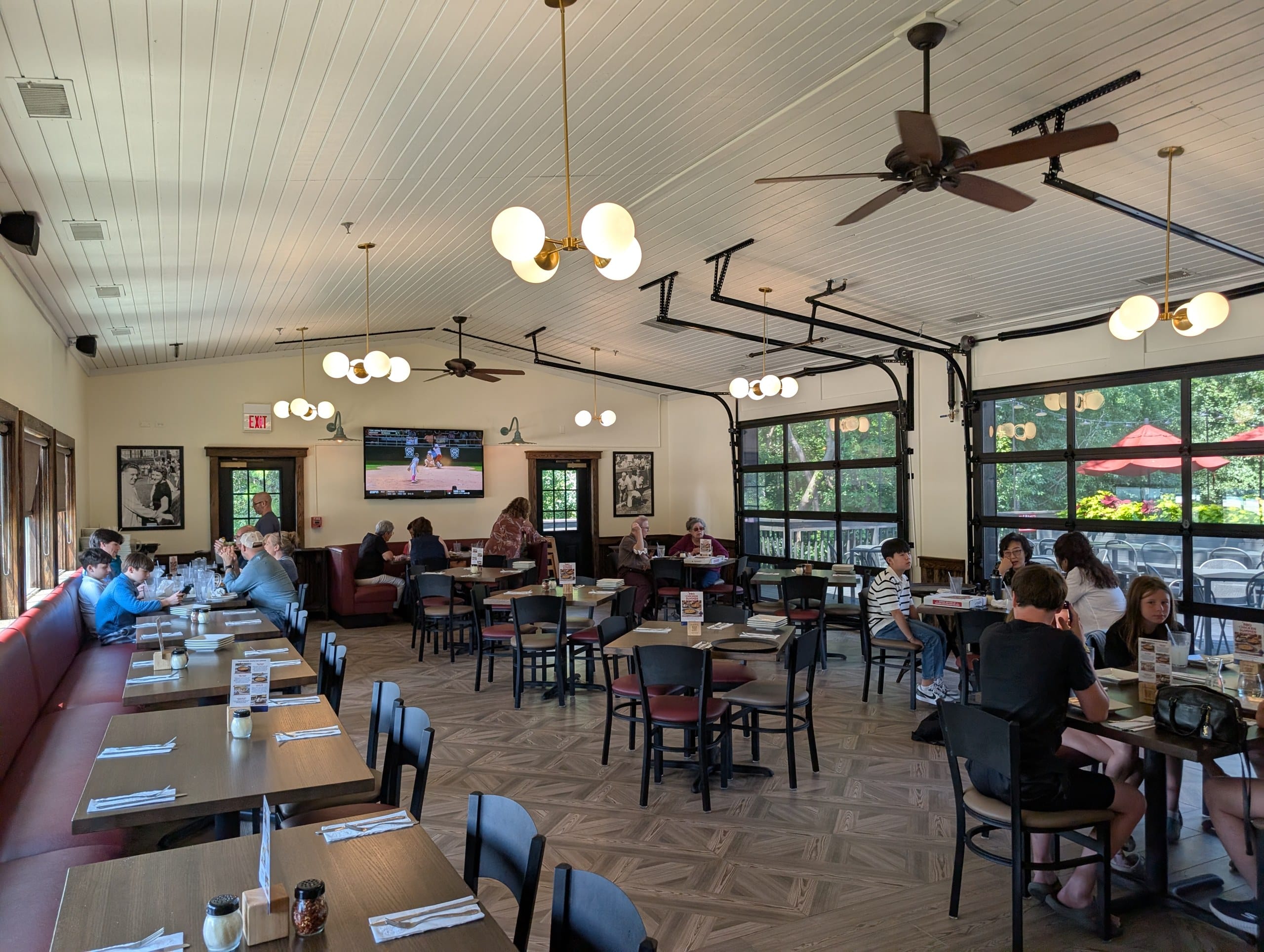 Main dining room at Lou Malnati's Buffalo Grove with white plank ceilings and doors opening toward the patio
