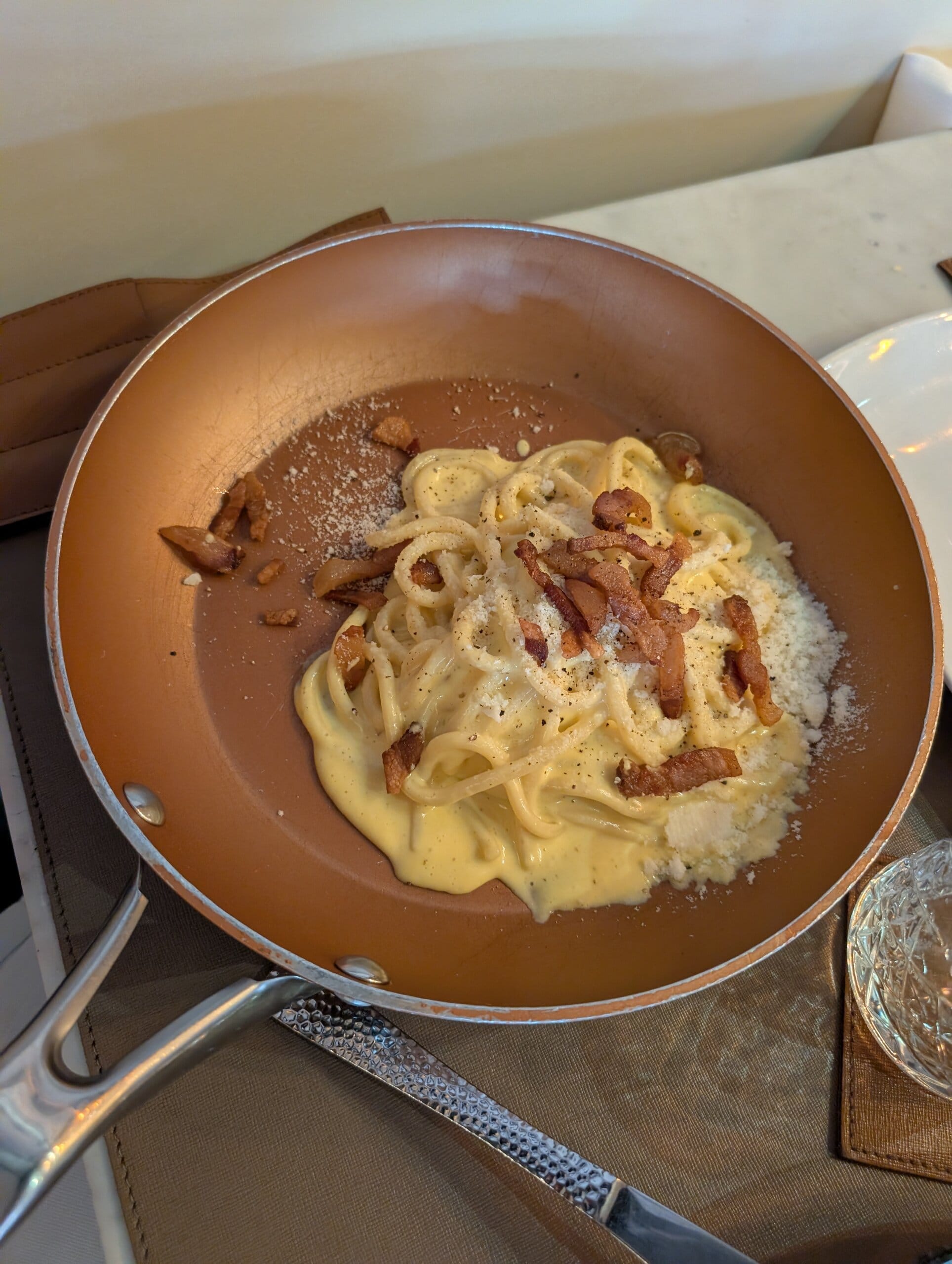 Carbonara served in a small copper pan topped with crisp bacon at Mylord in Civitavecchia