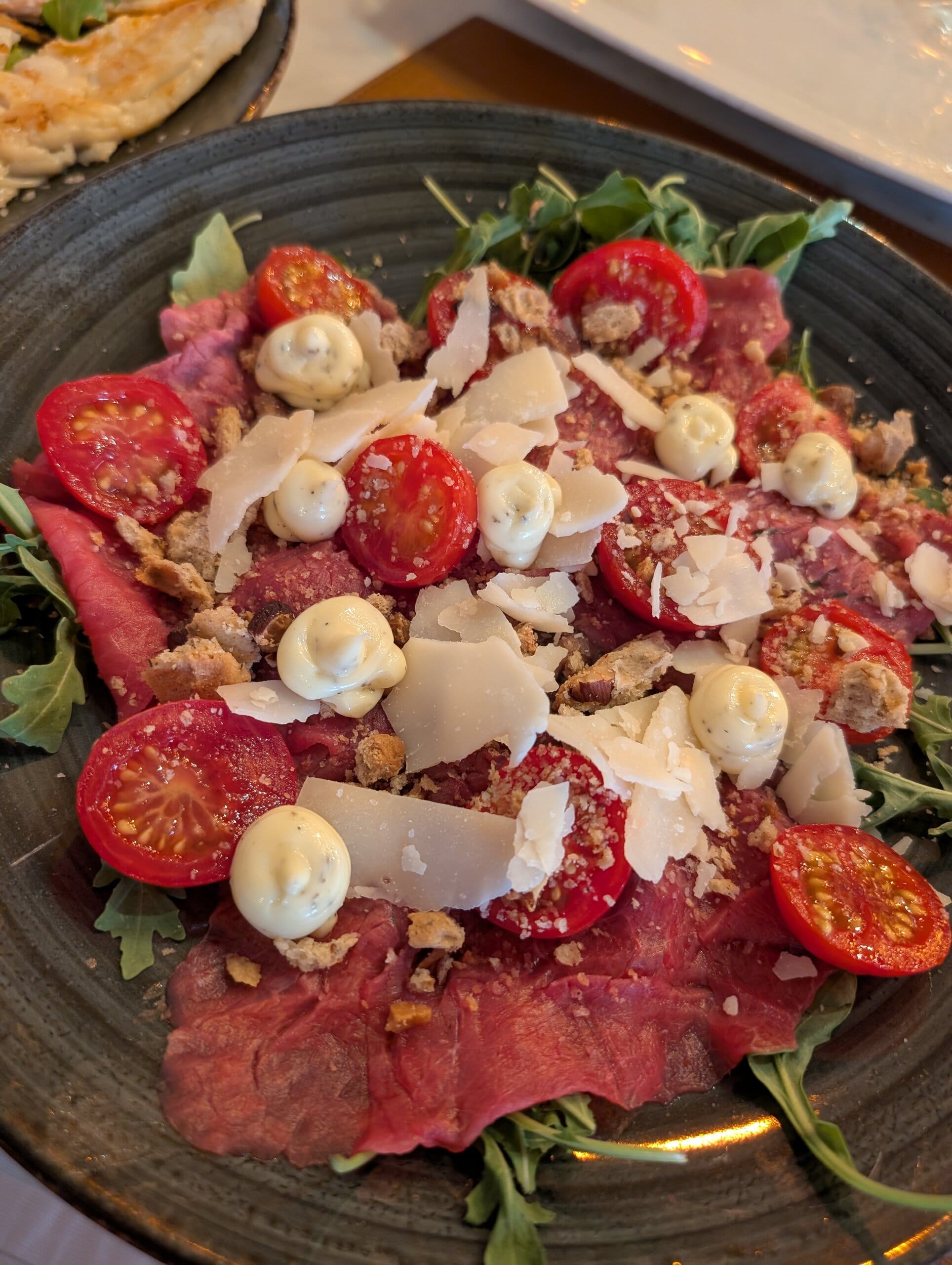 Carpaccio Piemontese with truffle mayonnaise, cherry tomatoes, arugula, shaved Grana and tarallo crumble at Mylord