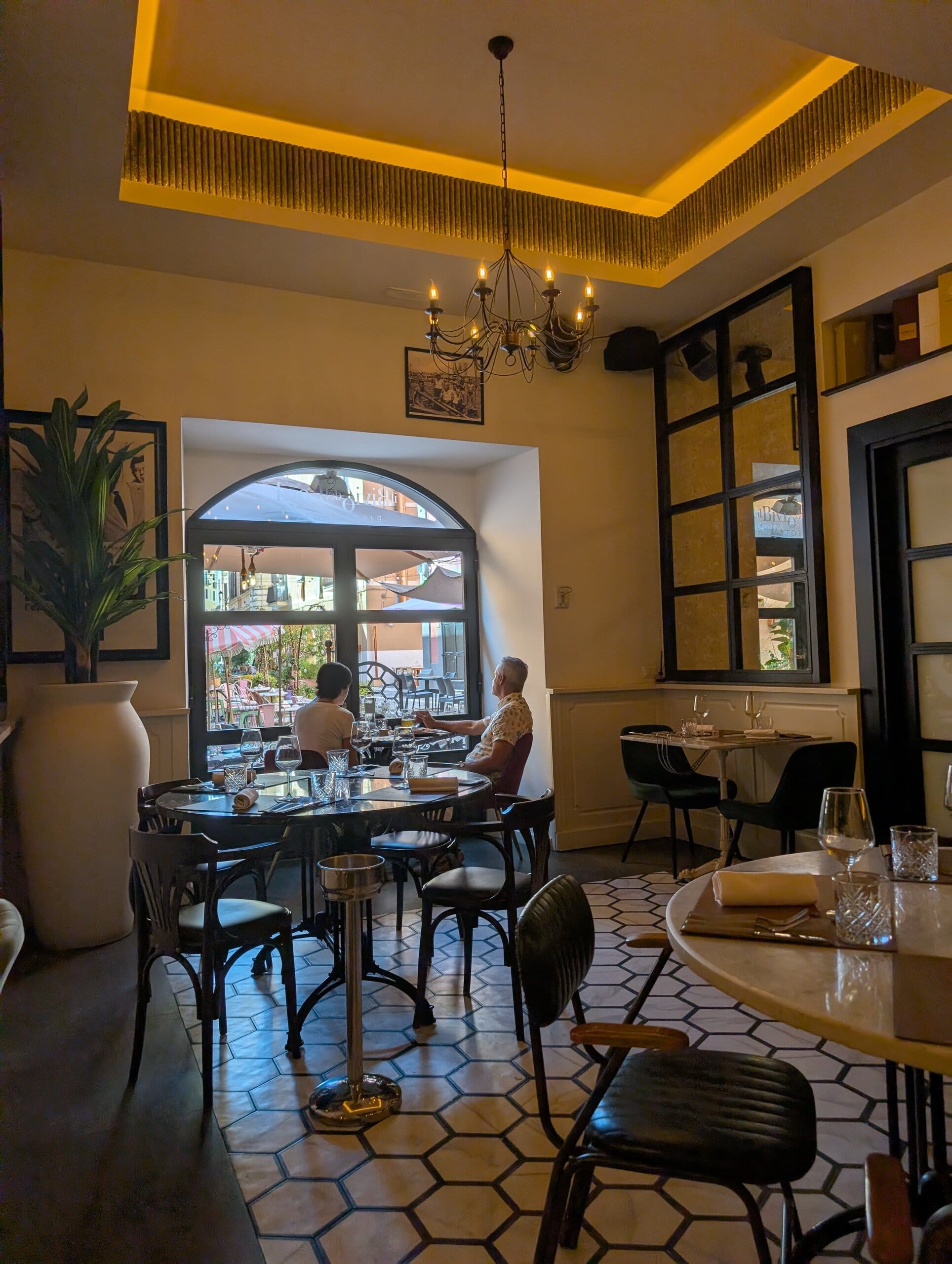 Front dining room at Mylord in Civitavecchia with chandelier, backlit ceiling and view of the terrace