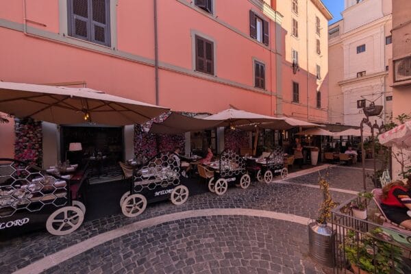 Cobblestone lane outside Mylord in Civitavecchia with honeycomb serving carts and outdoor tables