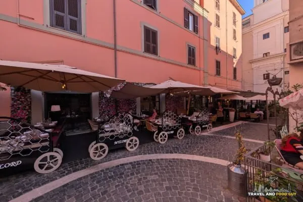Cobblestone lane outside Mylord in Civitavecchia with honeycomb serving carts and outdoor tables