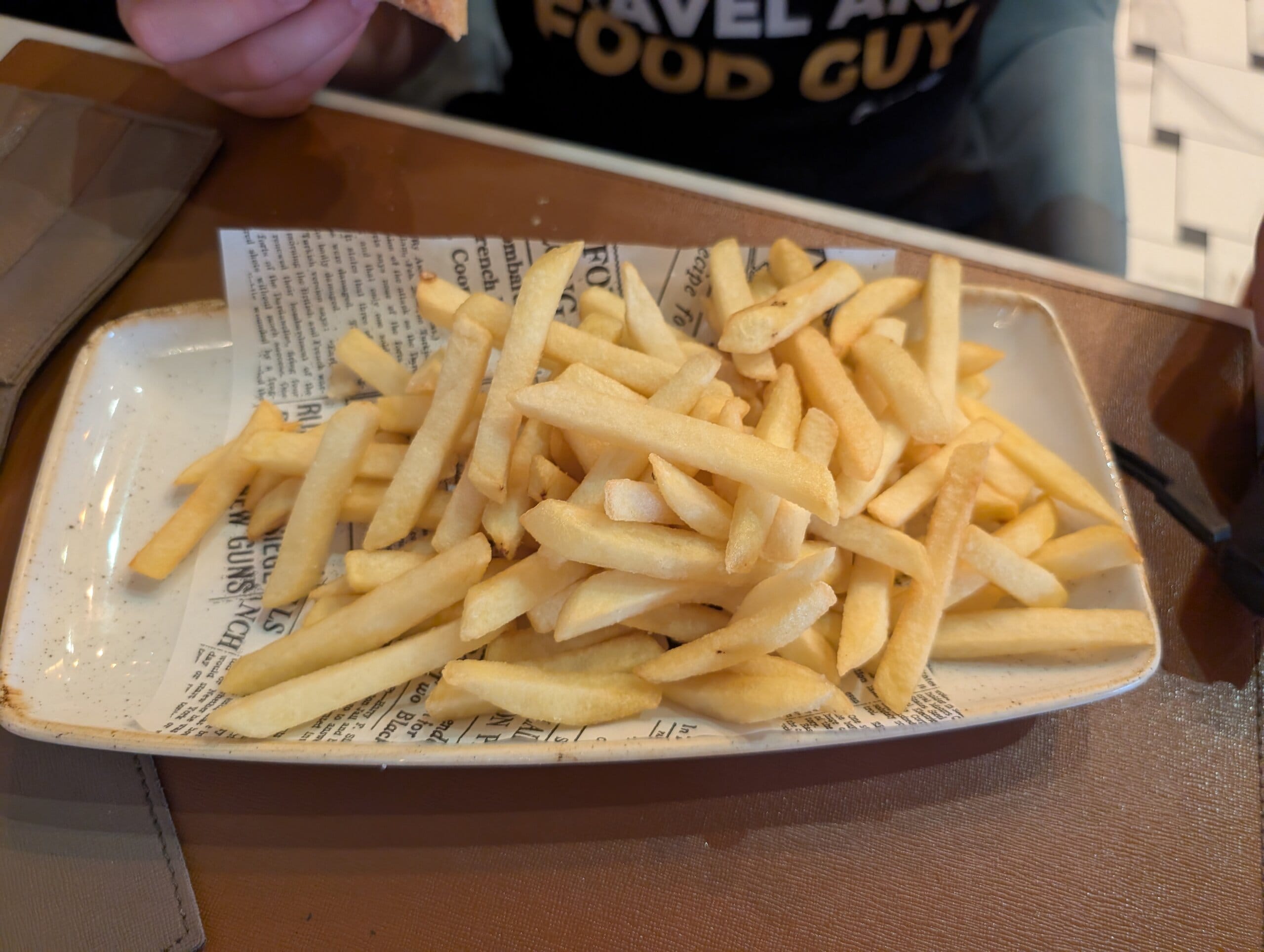 Plate of french fries on newspaper print paper at Mylord in Civitavecchia