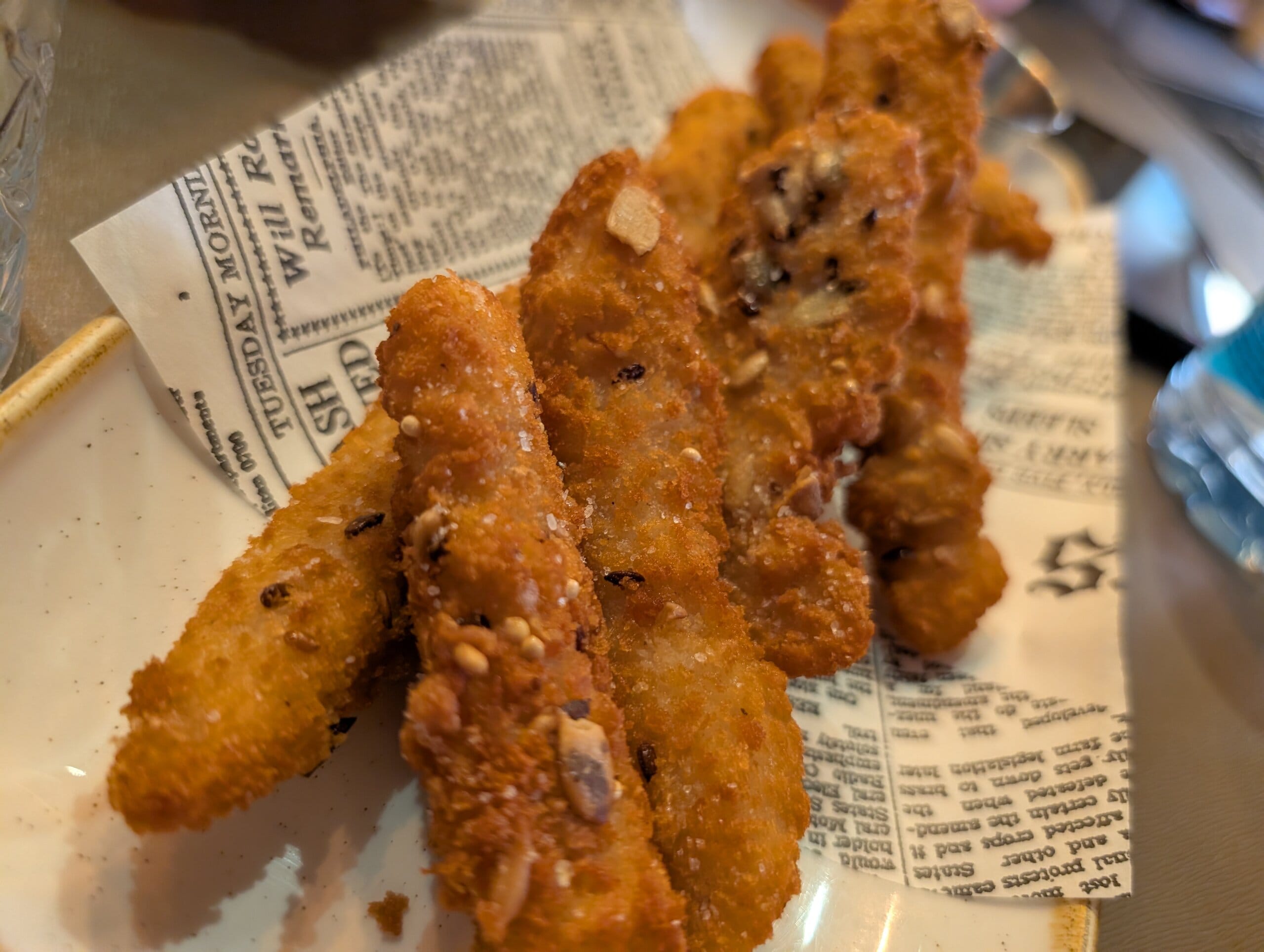 Cereal crusted chicken strips on newspaper print paper at Mylord in Civitavecchia
