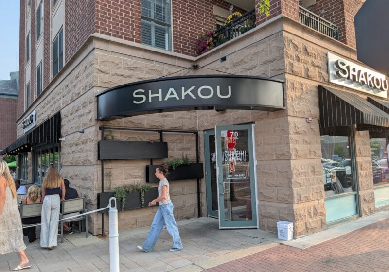 Shakou storefront on the corner of Vail Avenue in downtown Arlington Heights with black awnings and patio seating