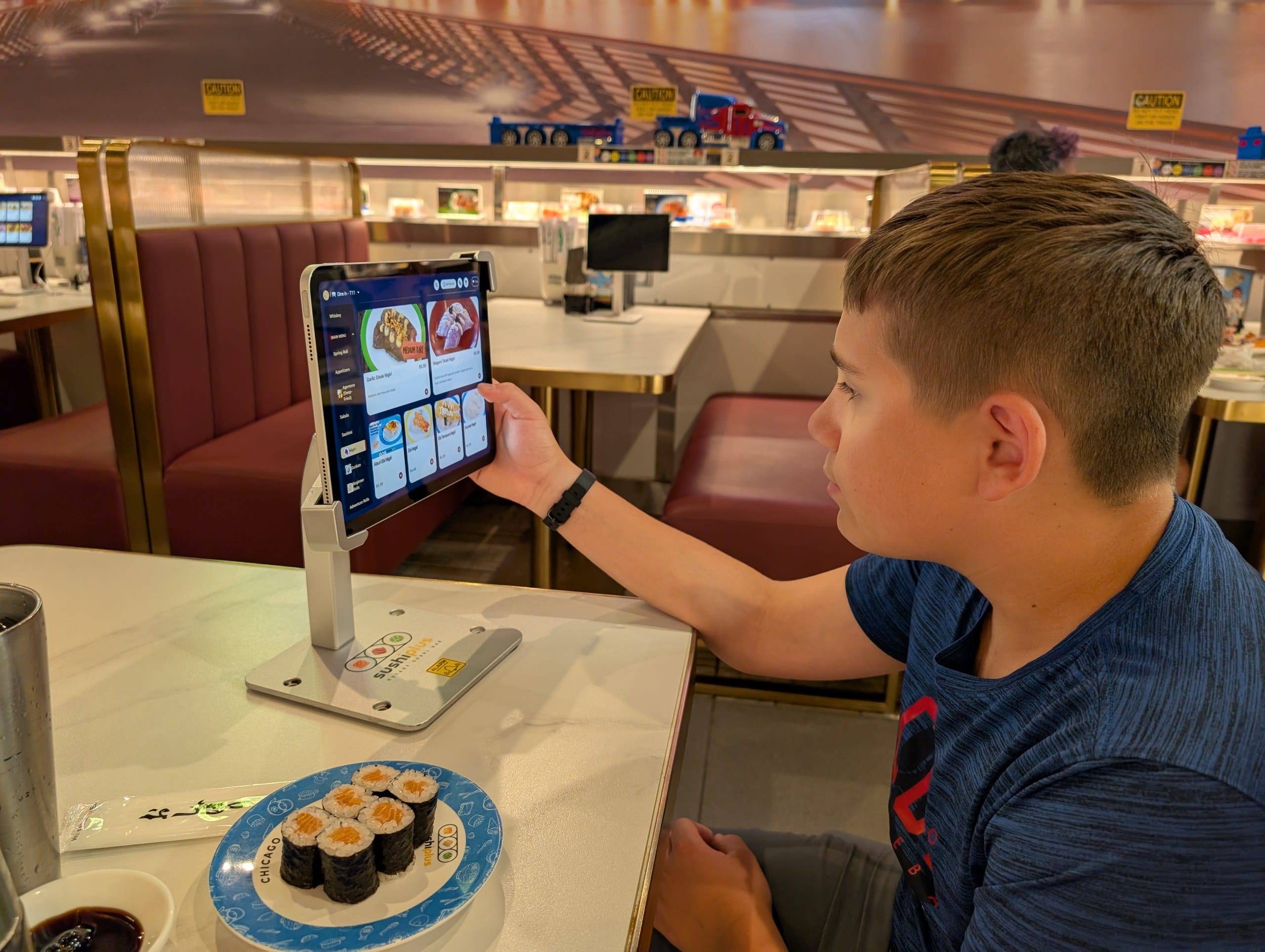 Ordering off the tabletop tablet at Sushi Plus, salmon maki on the plate