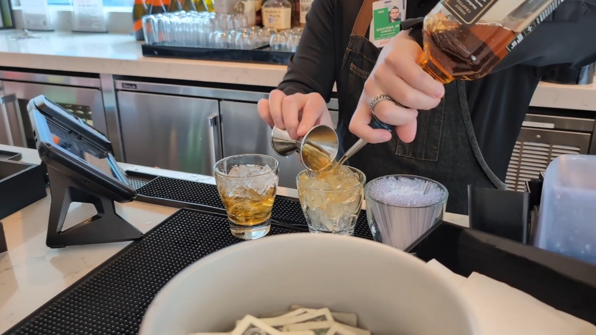 Bartender pouring a whiskey drink at the United Club LAX bar