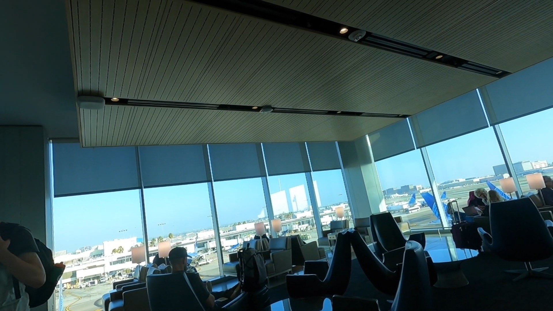 Swivel chairs facing tarmac views at the United Club LAX