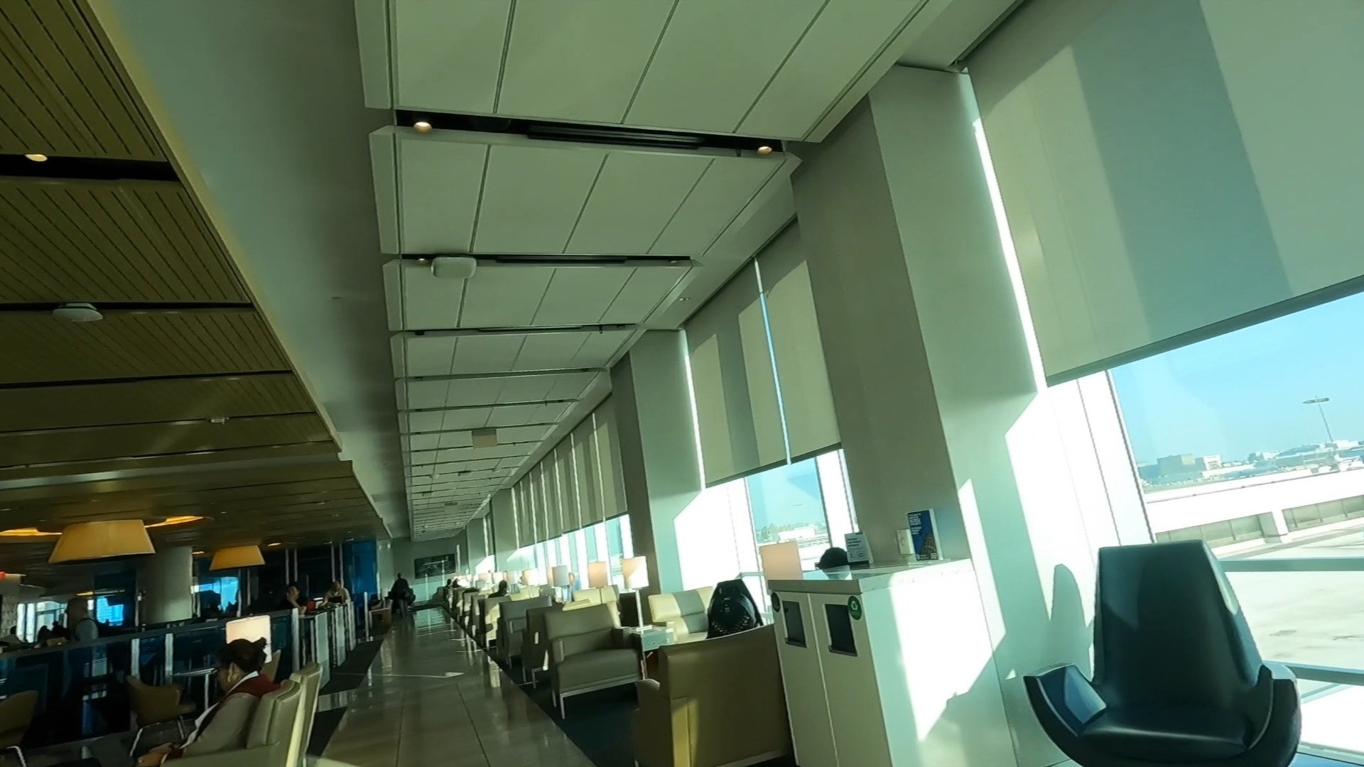 Lounge chairs along the floor-to-ceiling windows at the United Club LAX