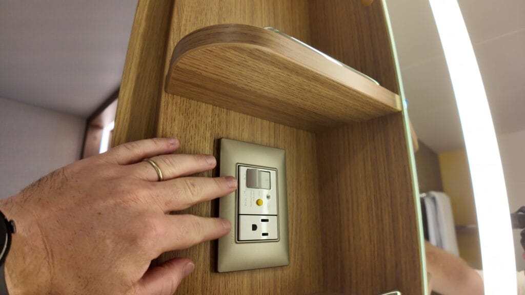 Bathroom power outlet and hook for a razor or hair dryer