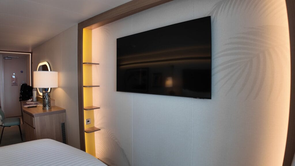 Television and shelving with accent lights in a Legend of the Seas balcony stateroom