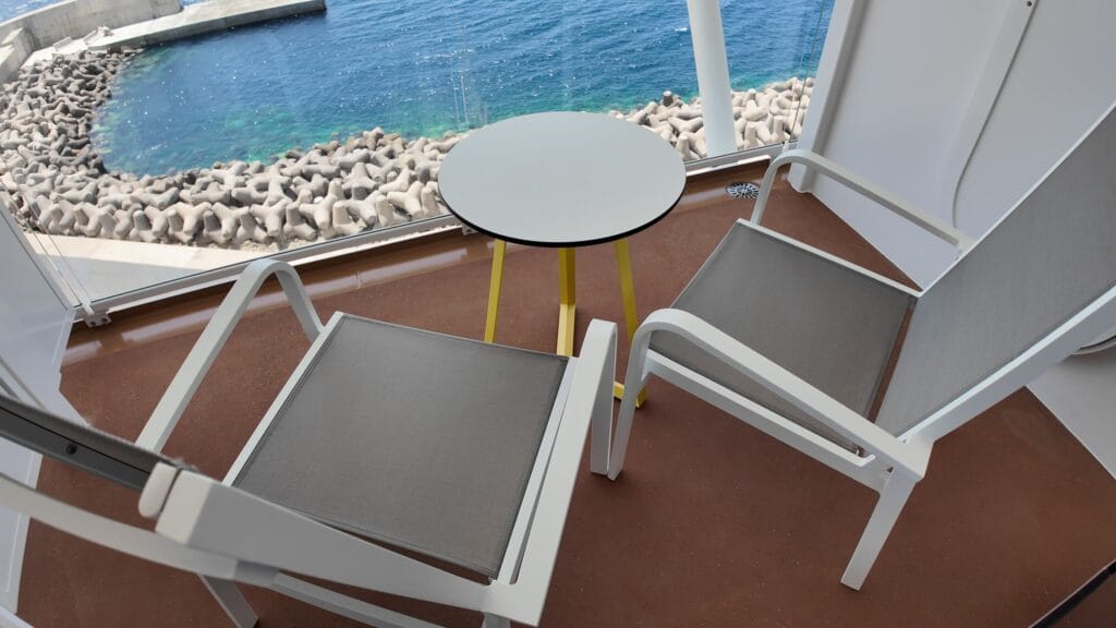 Balcony furniture, two chairs and a table, on a Legend of the Seas ocean view balcony