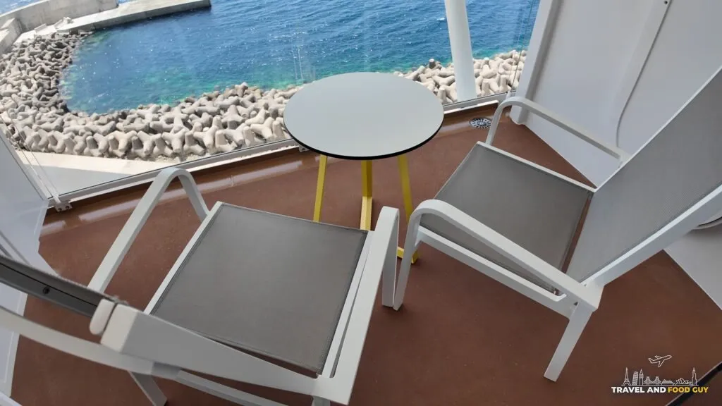 Balcony furniture, two chairs and a table, on a Legend of the Seas ocean view balcony