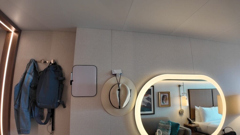 Ship hooks holding bags beside a small whiteboard brought from home