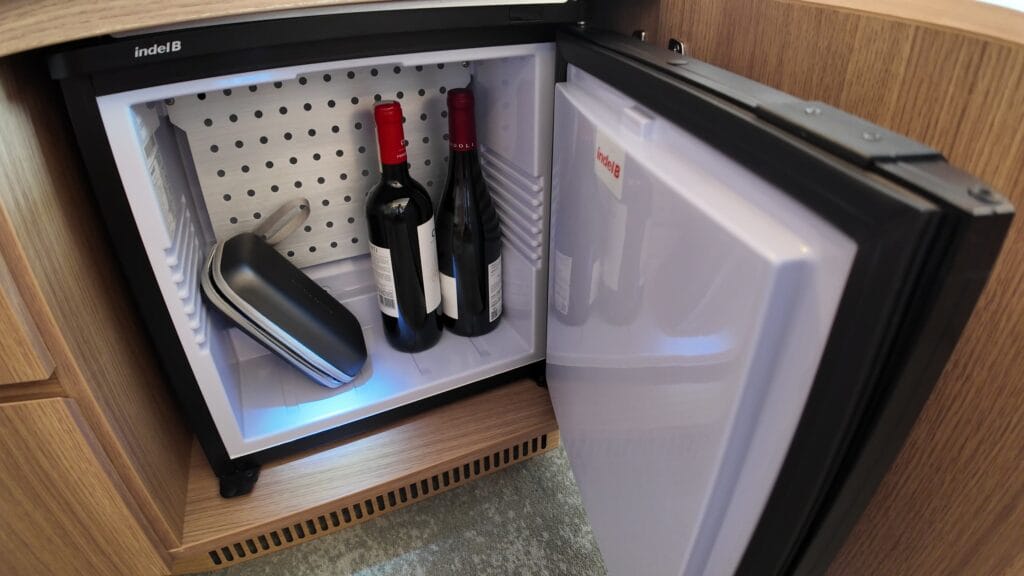 The mini fridge in stateroom 14632 holding two bottles of wine and medication