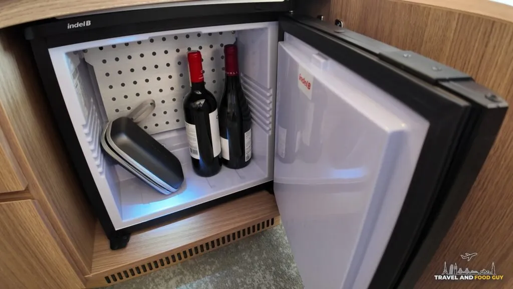 The mini fridge in stateroom 14632 holding two bottles of wine and medication