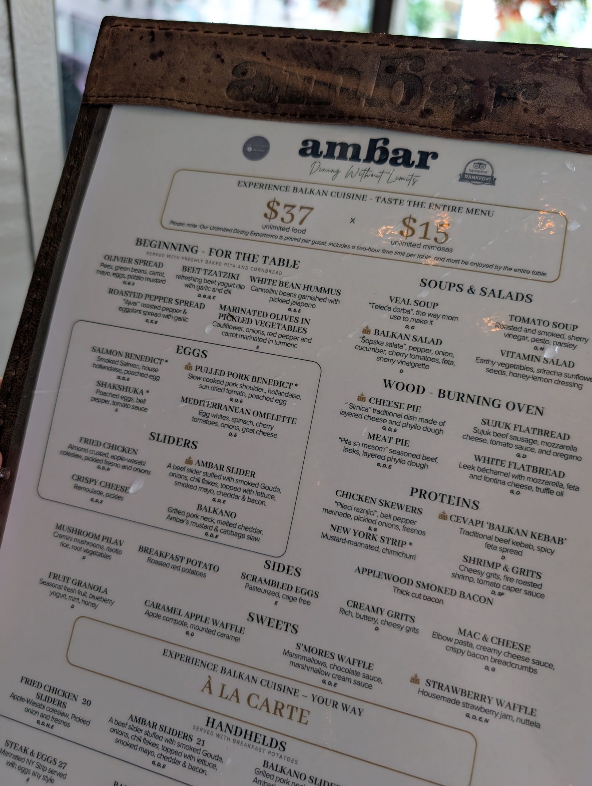 The brunch menu prices the unlimited experience at thirty seven dollars for food and fifteen dollars for unlimited mimosas, above the full list of Balkan plates.