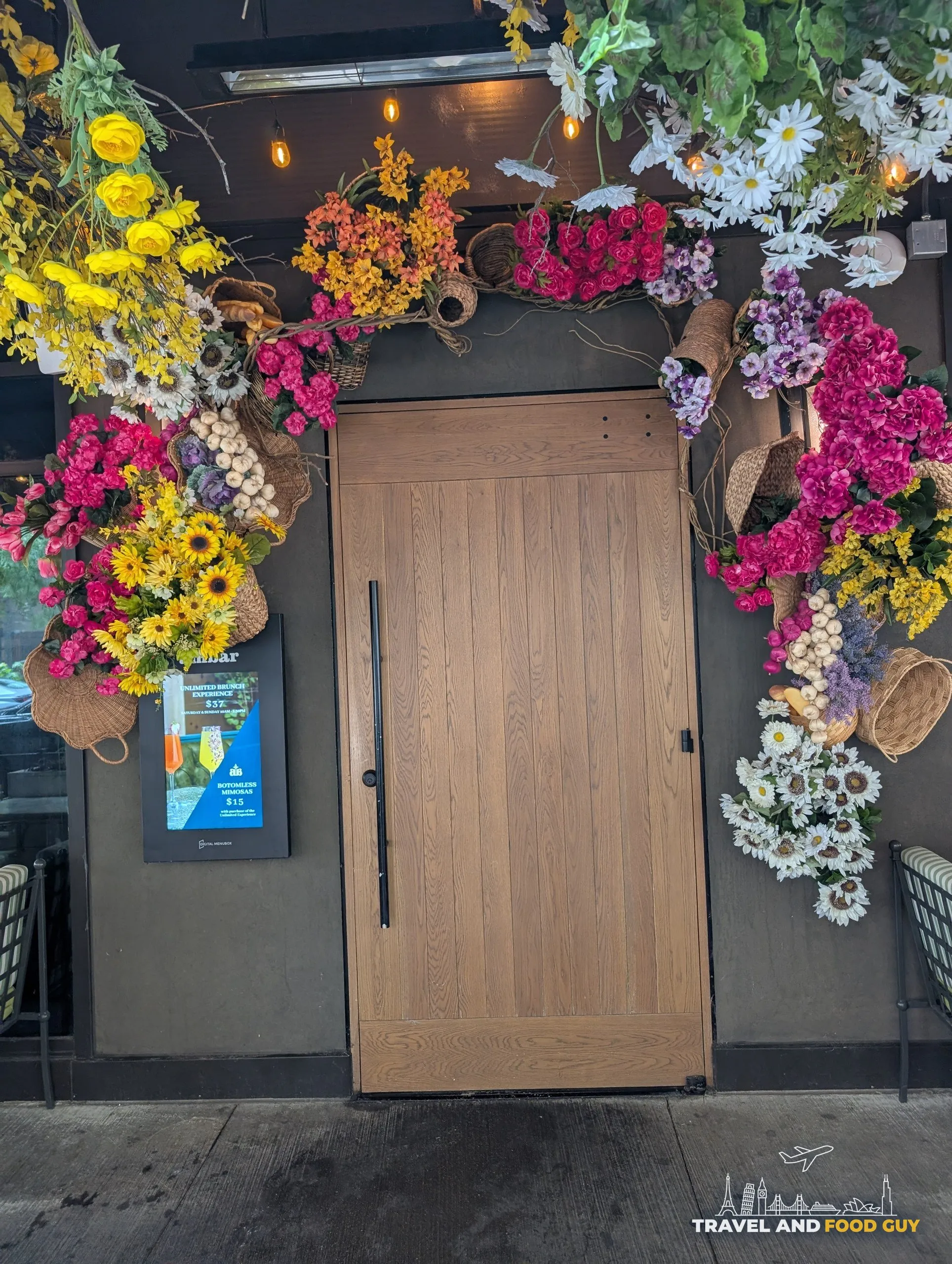 The oak front door is framed by baskets of sunflowers, roses and garlic braids, with the bottomless brunch board posted to the left.