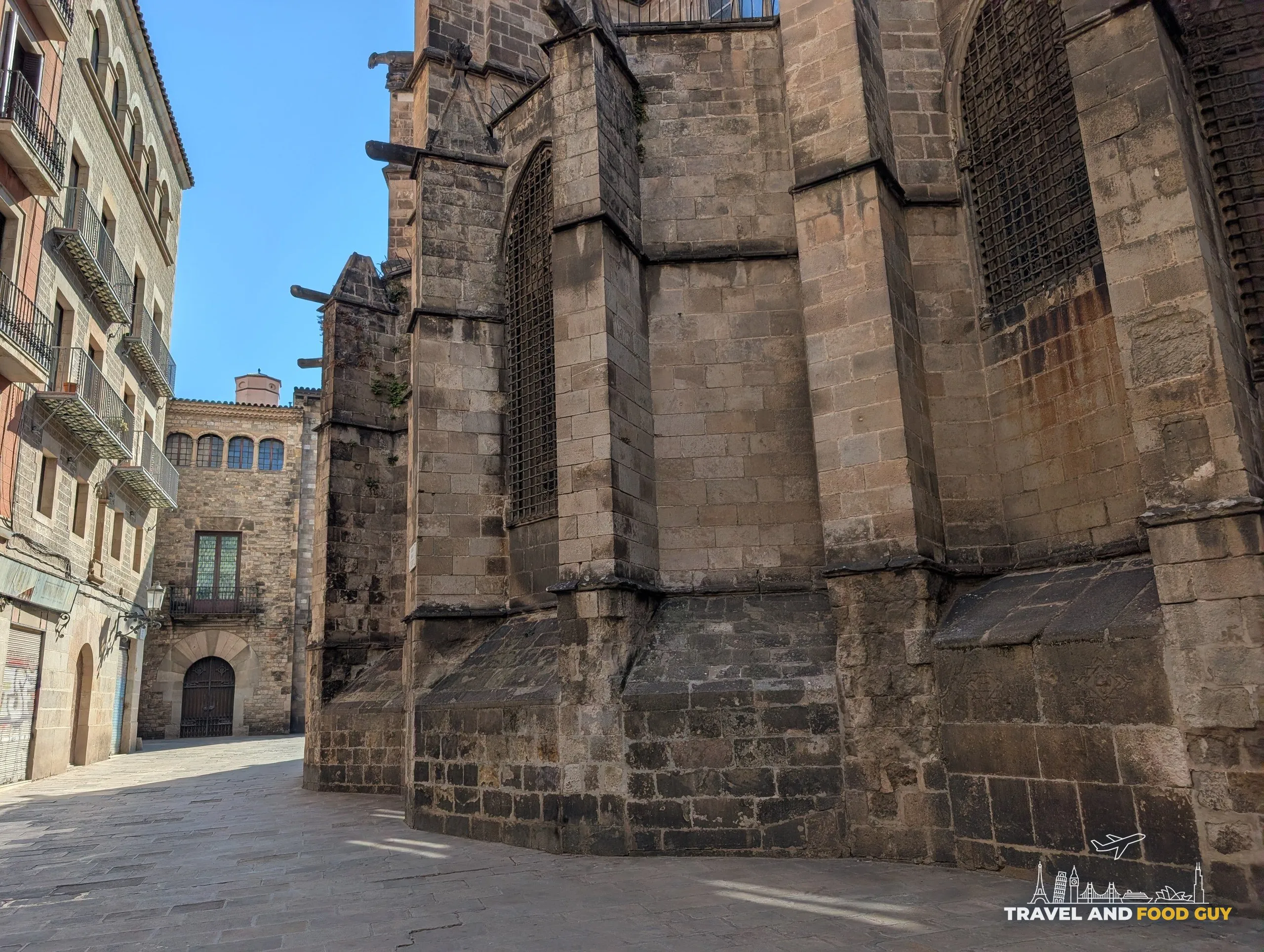 The stone apse of Barcelona Cathedral seen from a small square in the Gothic Quarter