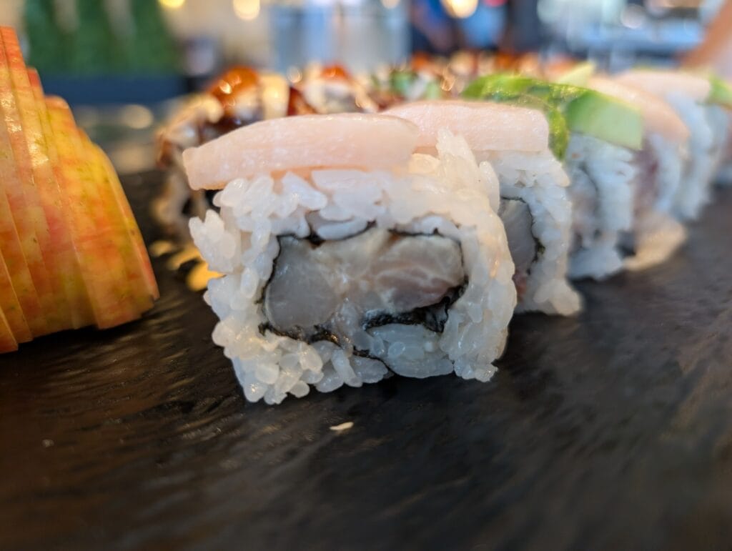 Yellowtail and avocado laid over the Hamachi Aisiteru roll, with the Fire Dragon behind it.