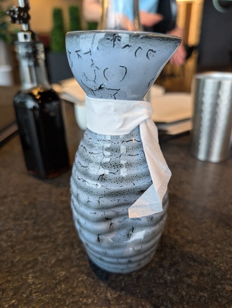 The eleven dollar large hot sake, served in a glazed carafe with the cup inverted over the neck.