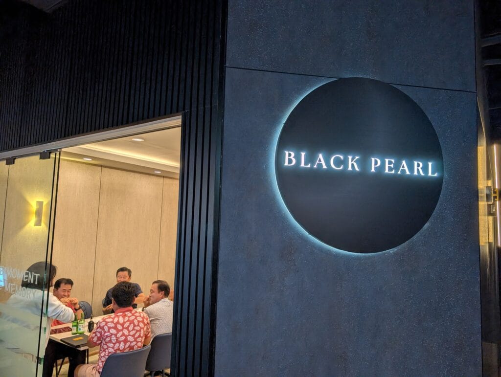 The backlit Black Pearl disc on the wall, with the glassed private dining room alongside it.