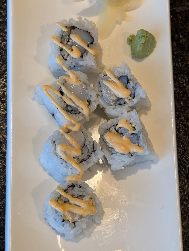 Six pieces of spicy scallop roll with ginger and wasabi, eleven dollars, and the only roll we finished.