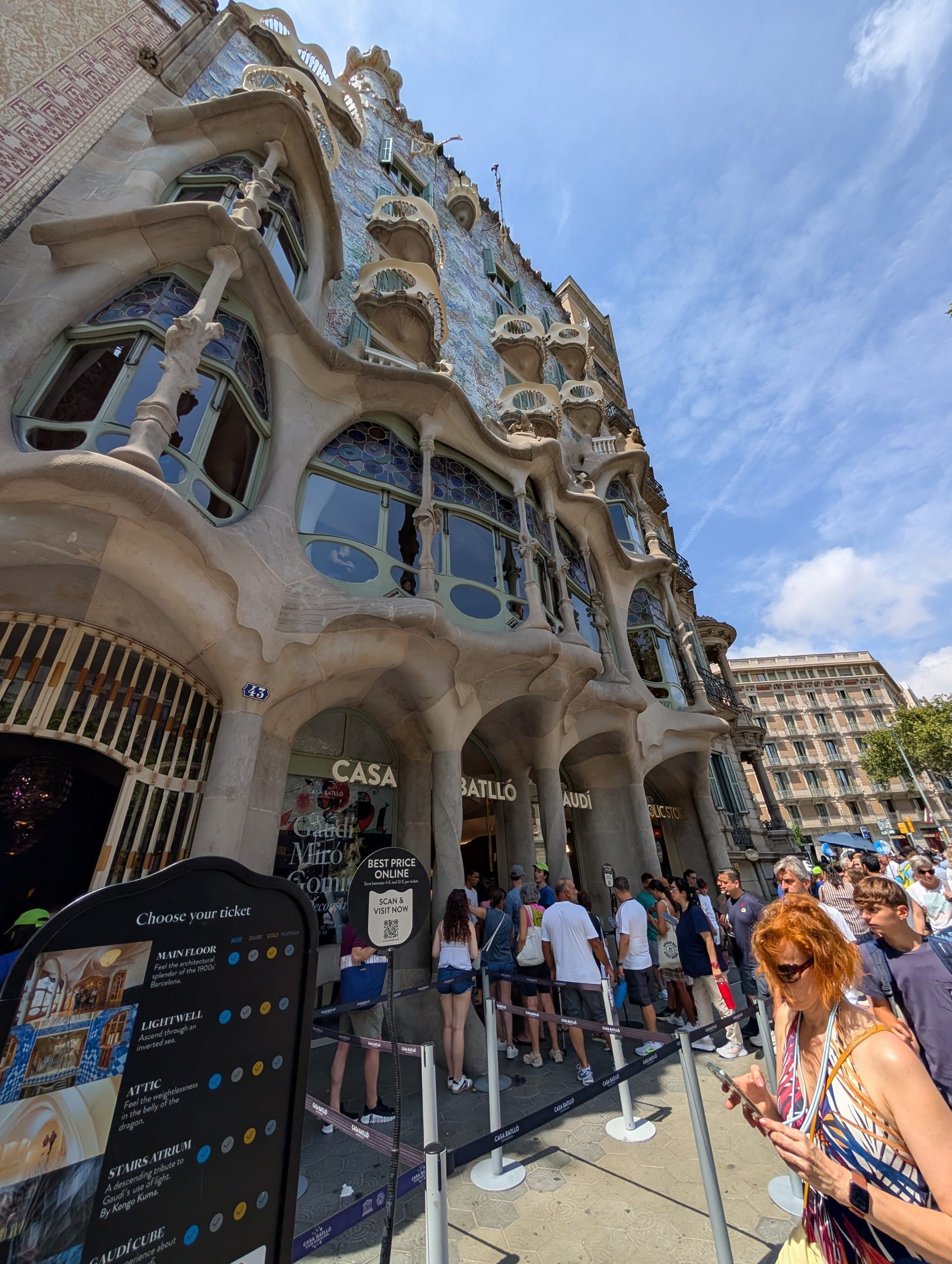 The Casa Batlló facade on Passeig de Gràcia with the midday ticket queue