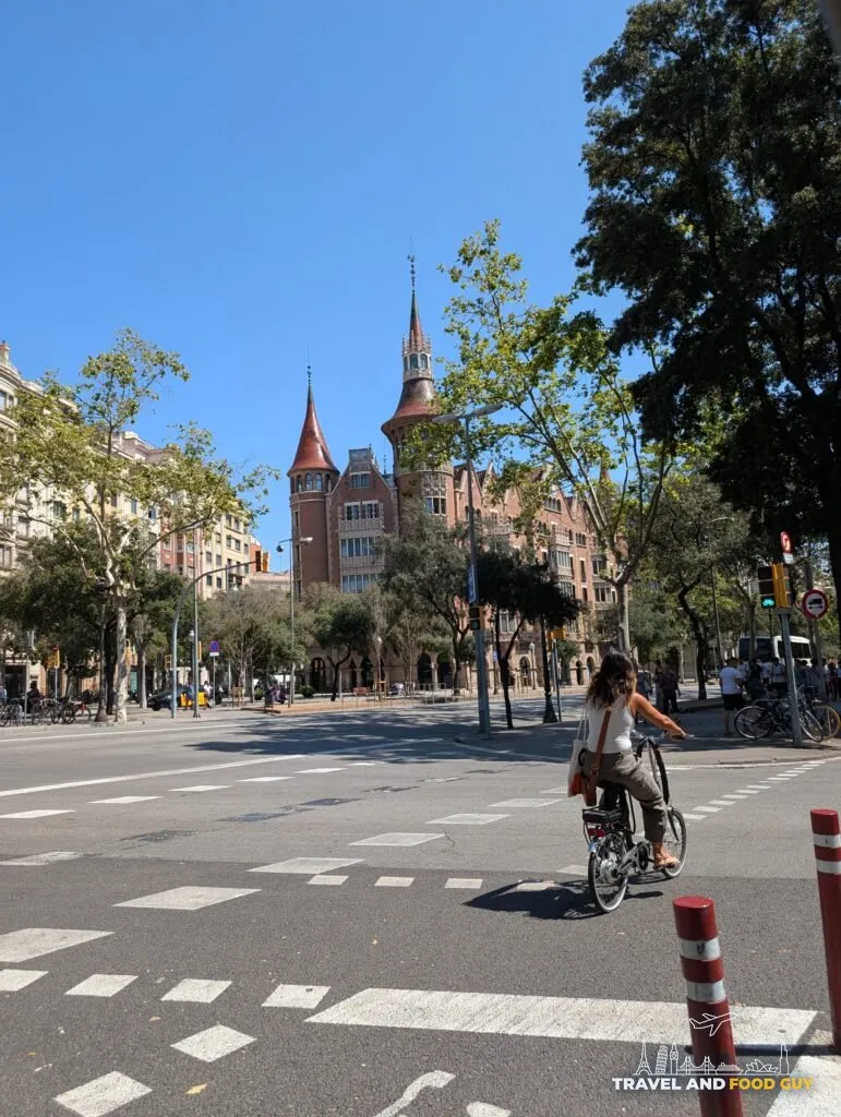 A cyclist crossing a wide Eixample intersection near Casa de les Punxes in Barcelona